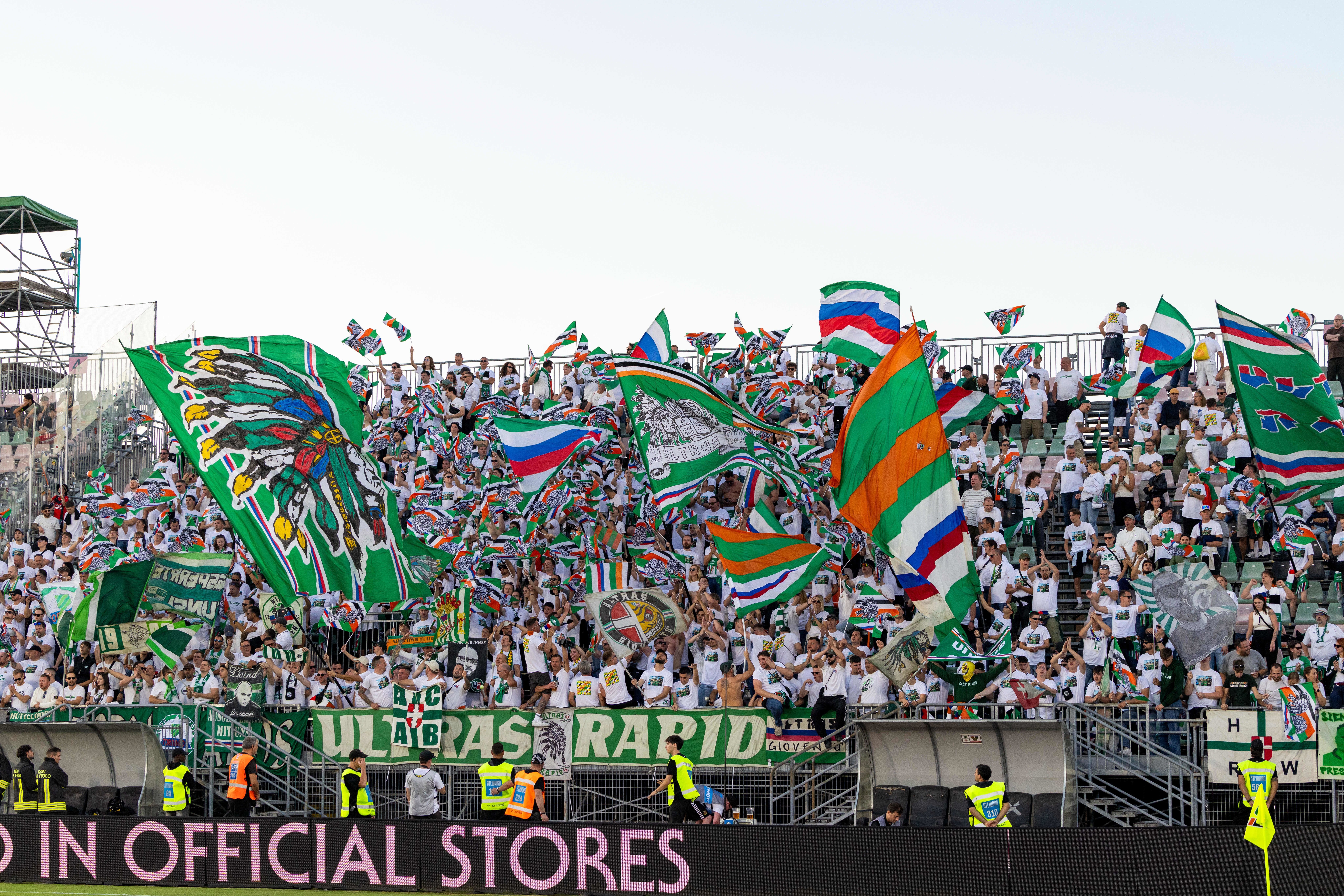 Viele Rapid-Fans schwenken grüne Fahnen und jubeln im Fußballstadion.