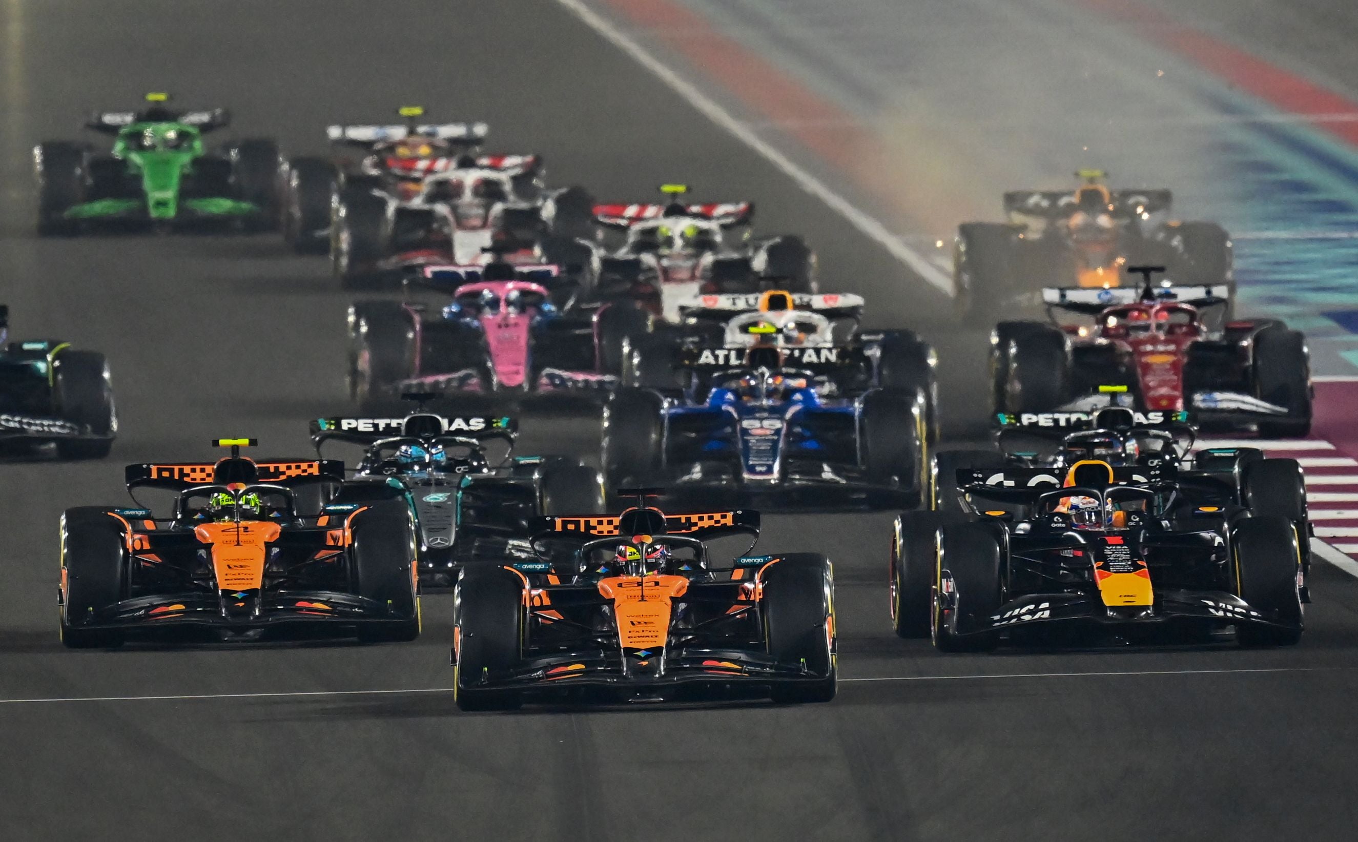 Formel-1-Autos starten beim Großen Preis von Katar auf dem Lusail International Circuit bei Nacht.