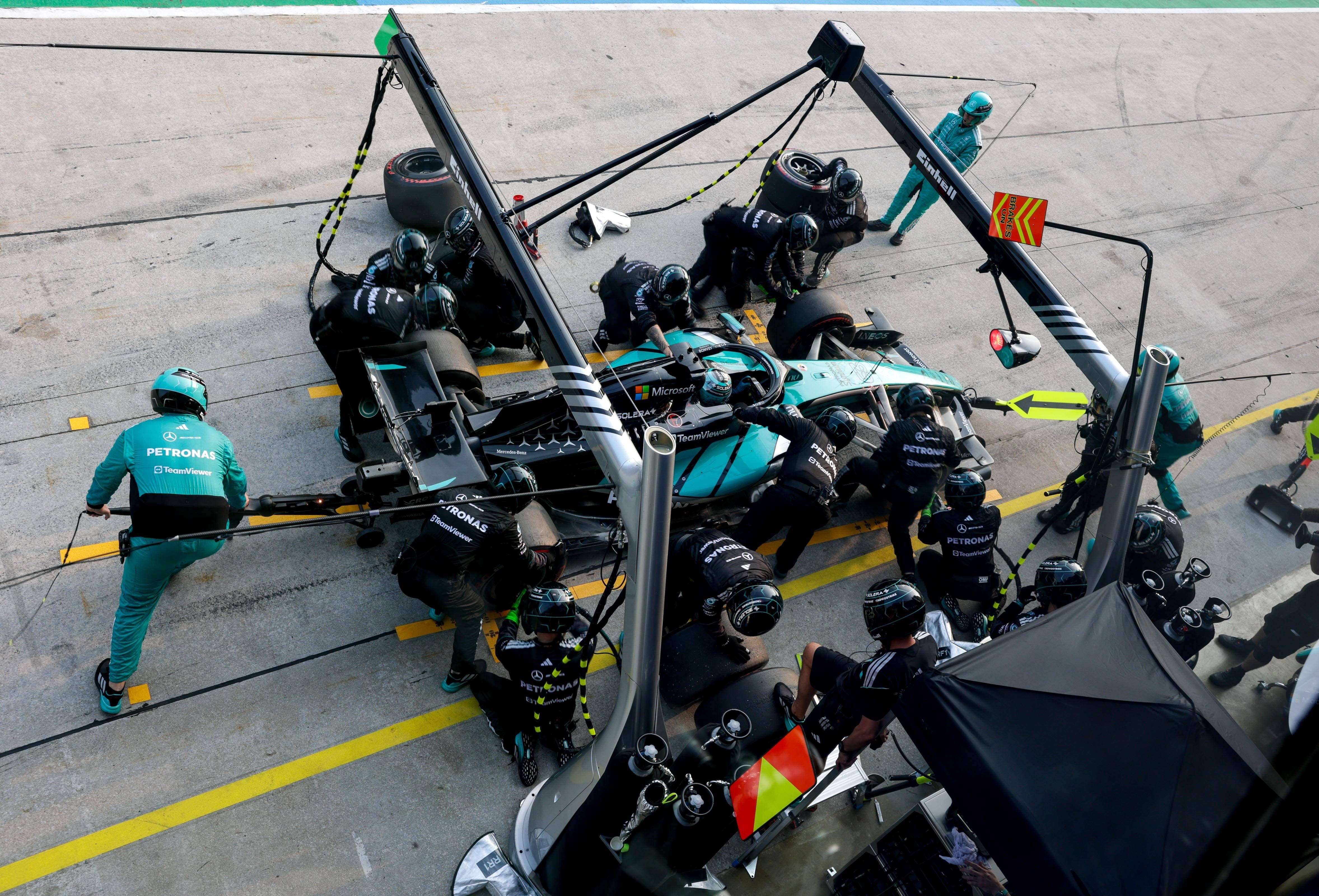 Boxenstopp eines Mercedes-Formel-1-Wagens mit mehreren Mechanikern an der Boxengasse.