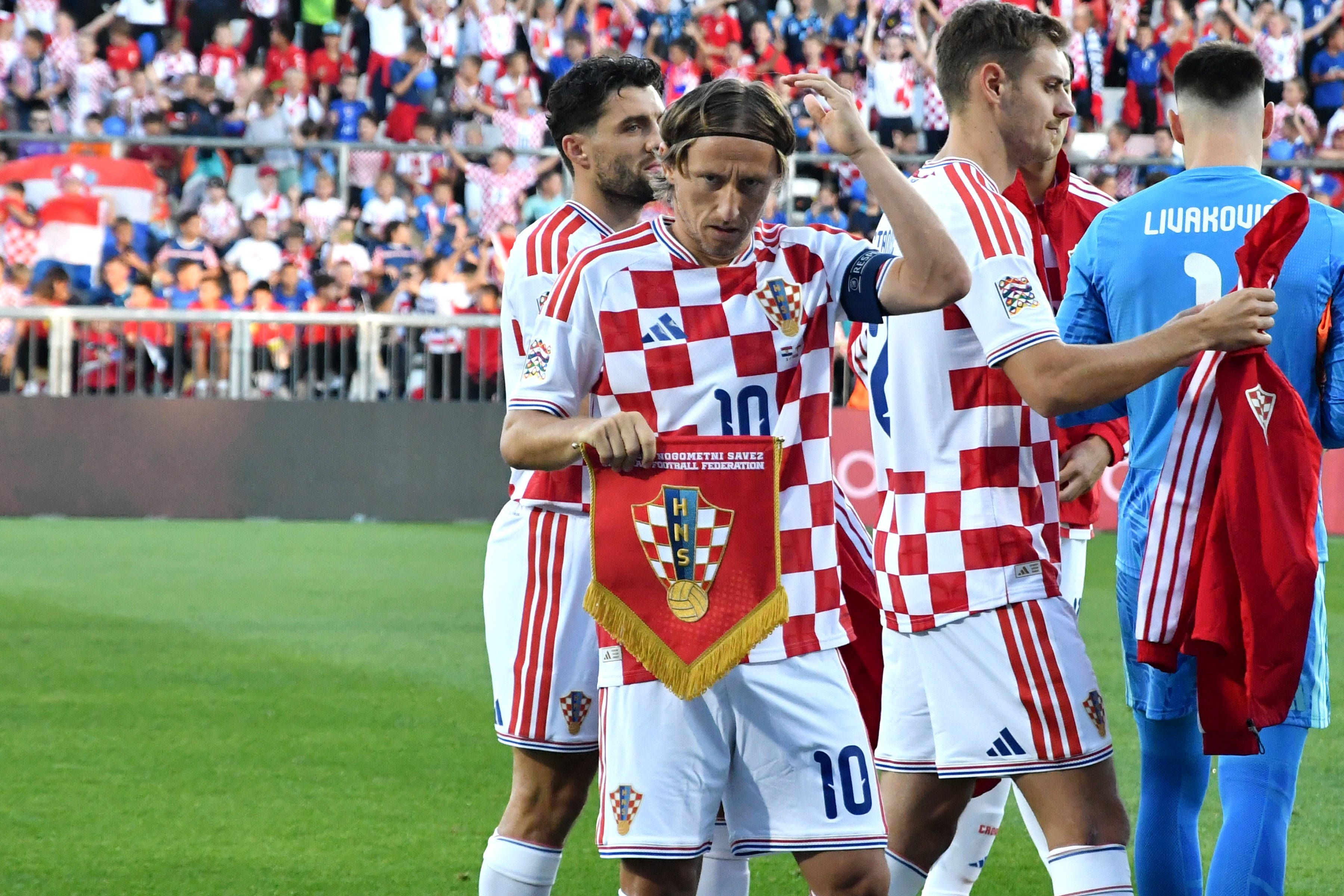 Luka Modric steht mit kroatischen Spielern im Trikot vor einem Spiel im Stadion.