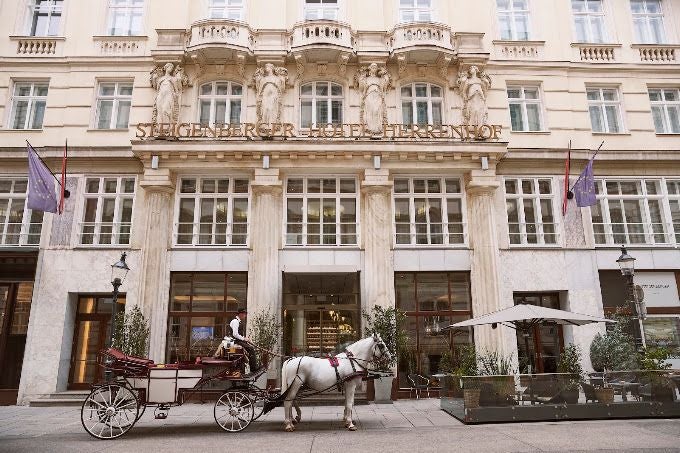 Pferdekutsche vor dem Steigenberger Hotel Herrenhof in einer historischen Straßenkulisse.