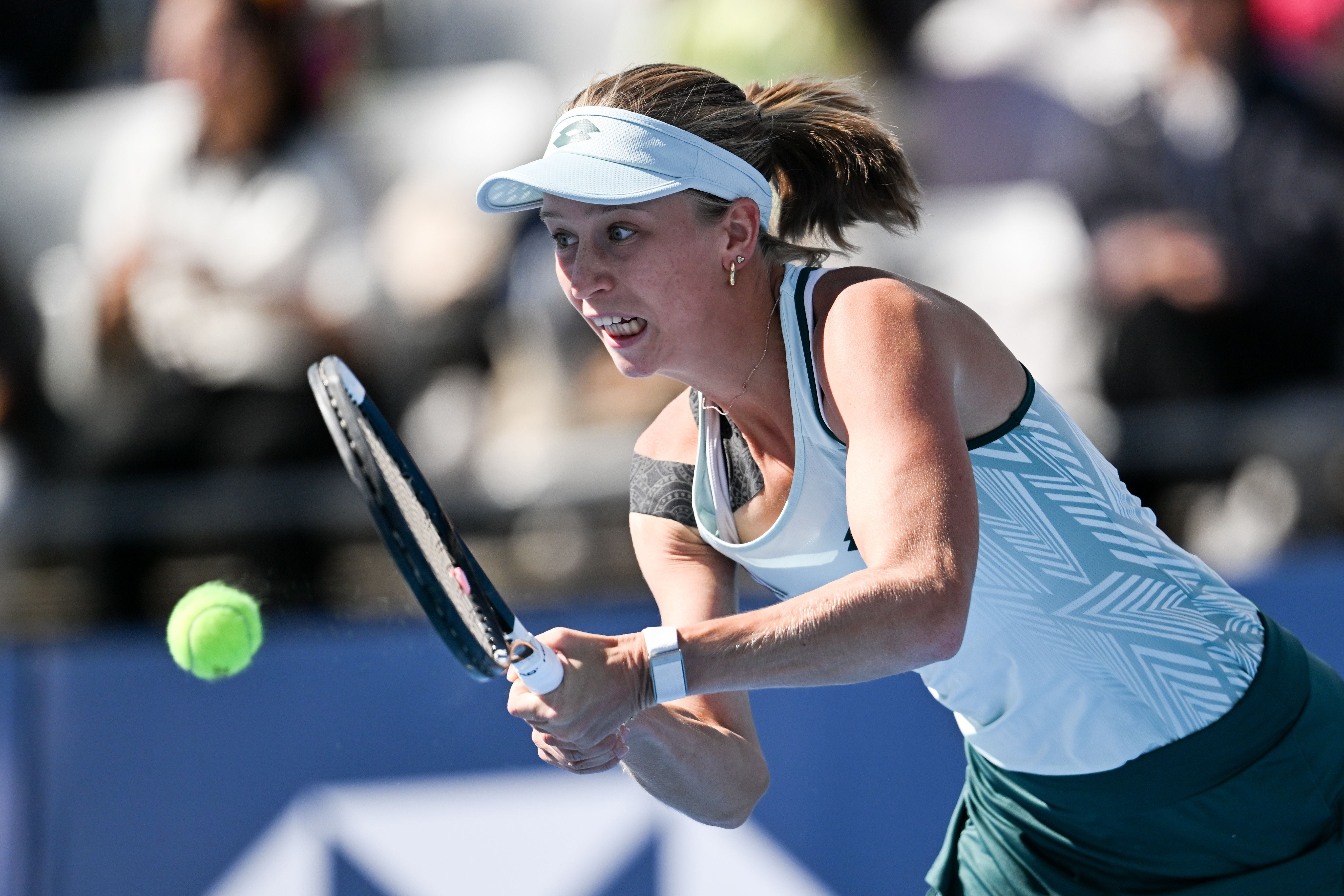Tennisspielerin konzentriert sich beim Rückhandschlag während eines Matches auf den Ball.