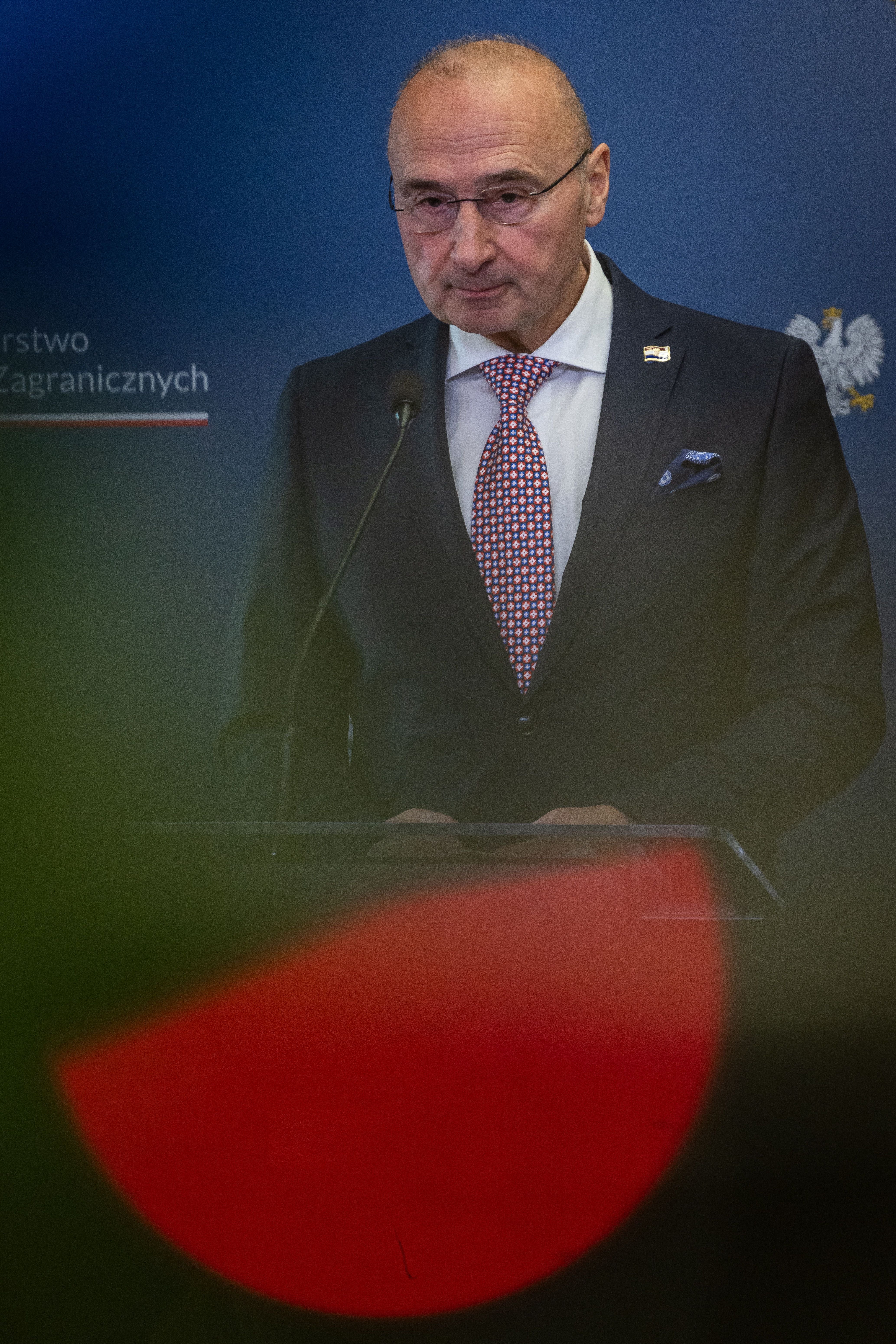Ein Mann im Anzug spricht auf einer Pressekonferenz an einem Rednerpult.