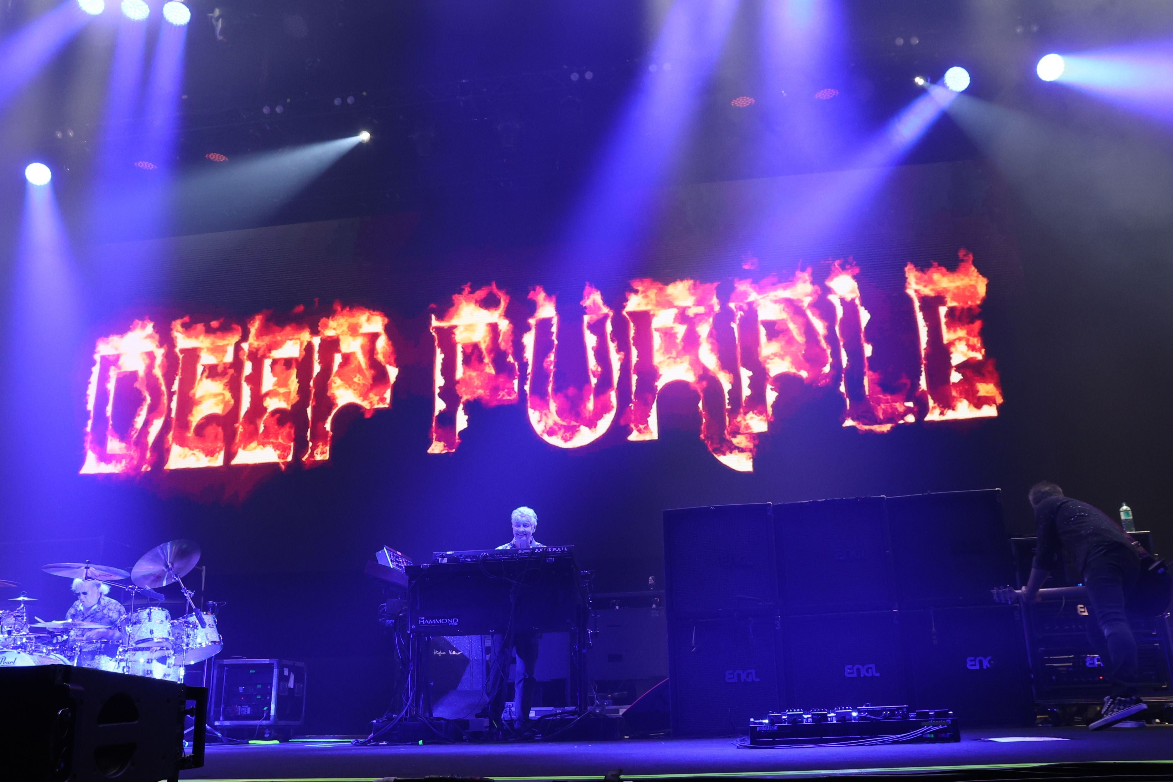 Bühnenbild der Band Deep Purple mit feurigem Logo im Hintergrund bei einem Livekonzert.