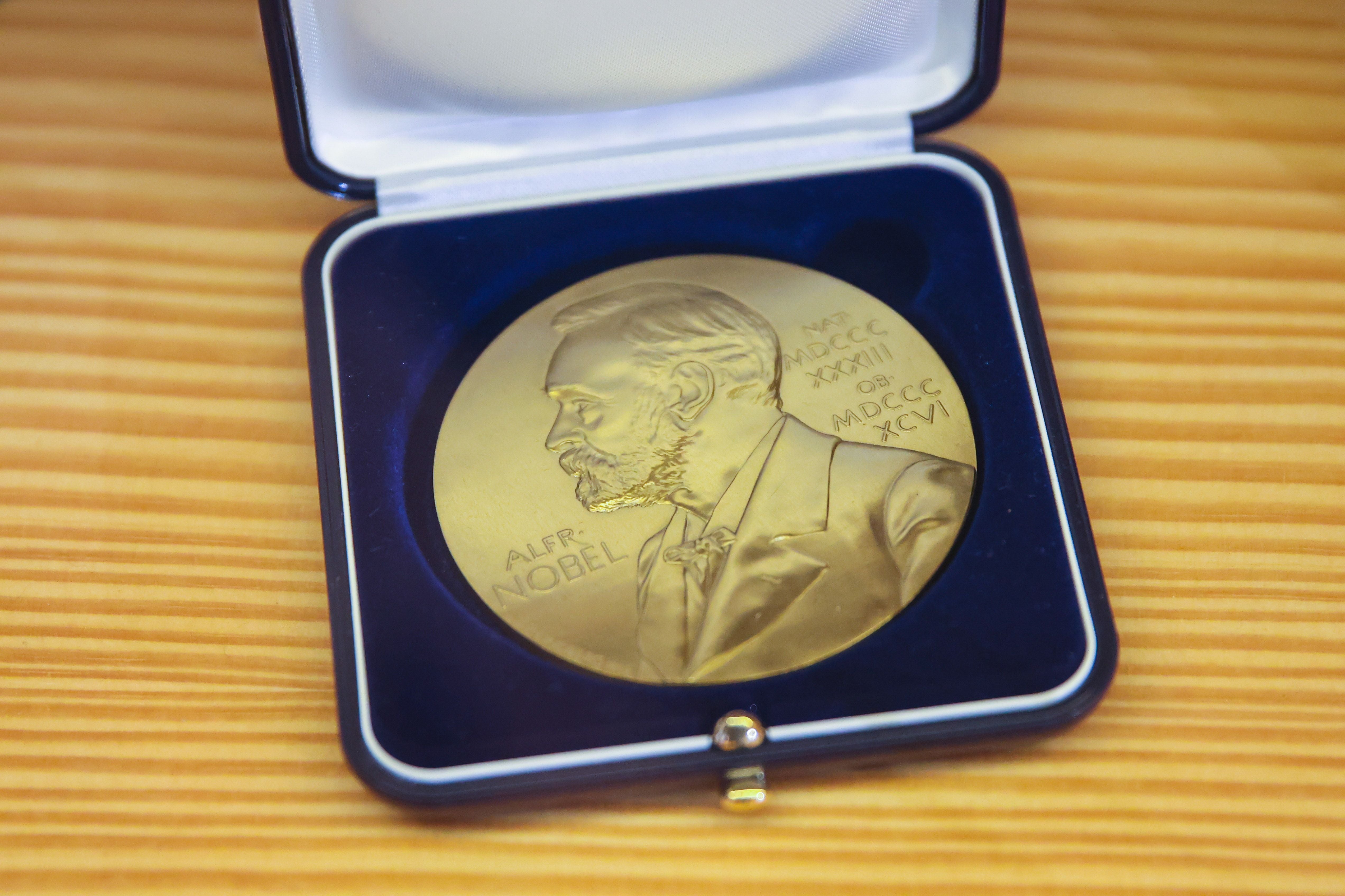 Goldene Nobelpreis-Medaille in einer offenen Box auf einem Holztisch.