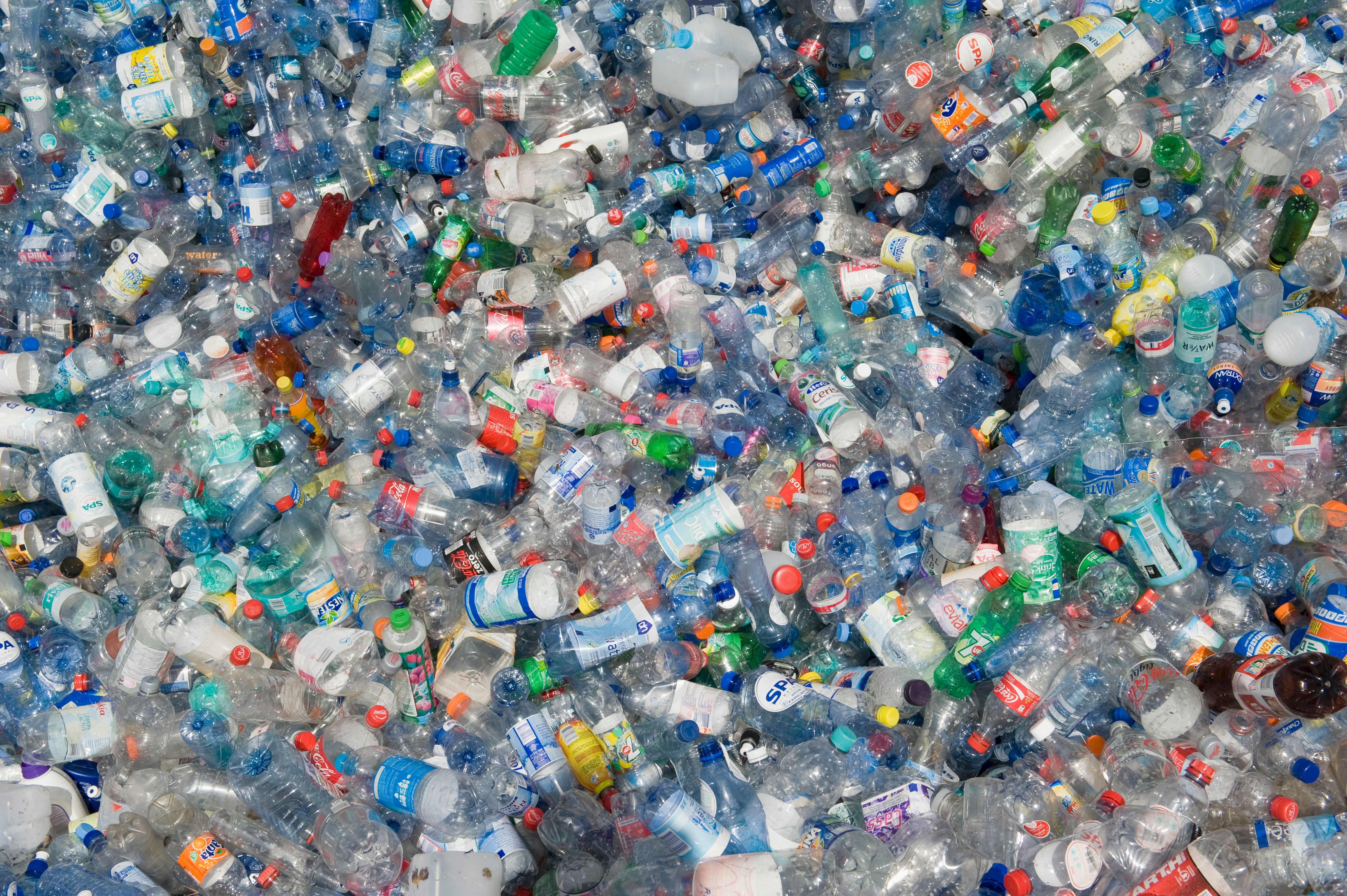 Viele bunte, leere Plastikflaschen liegen dicht aneinander gestapelt.