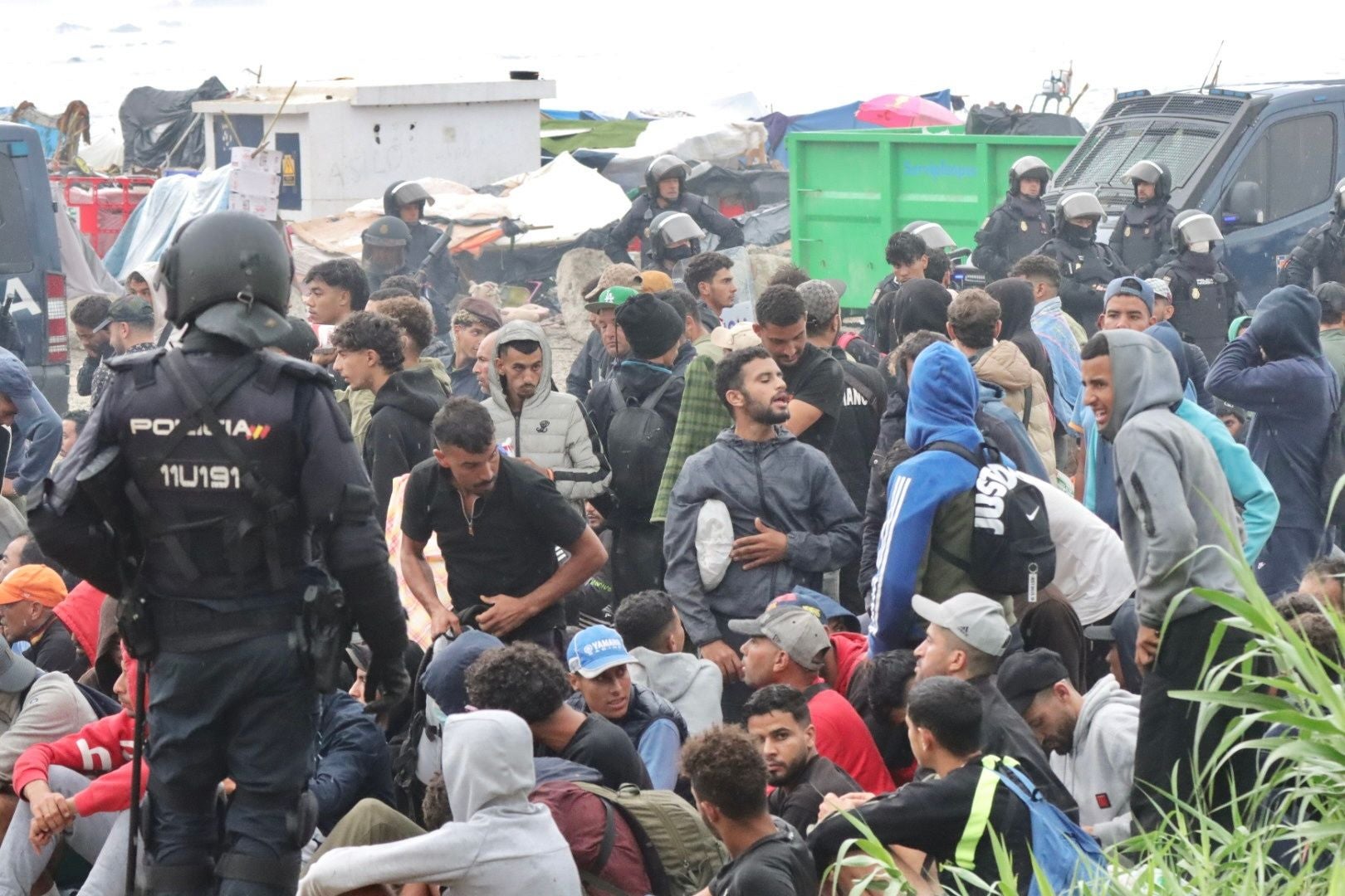 Viele Polizisten räumen ein Lager mit zahlreichen Migranten an einem Strand in Ceuta, Spanien.
