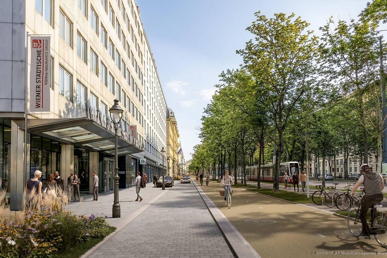 Menschen gehen und fahren Fahrrad auf der neu gestalteten Wiener Ringstraße mit Bäumen und Straßenbahn.