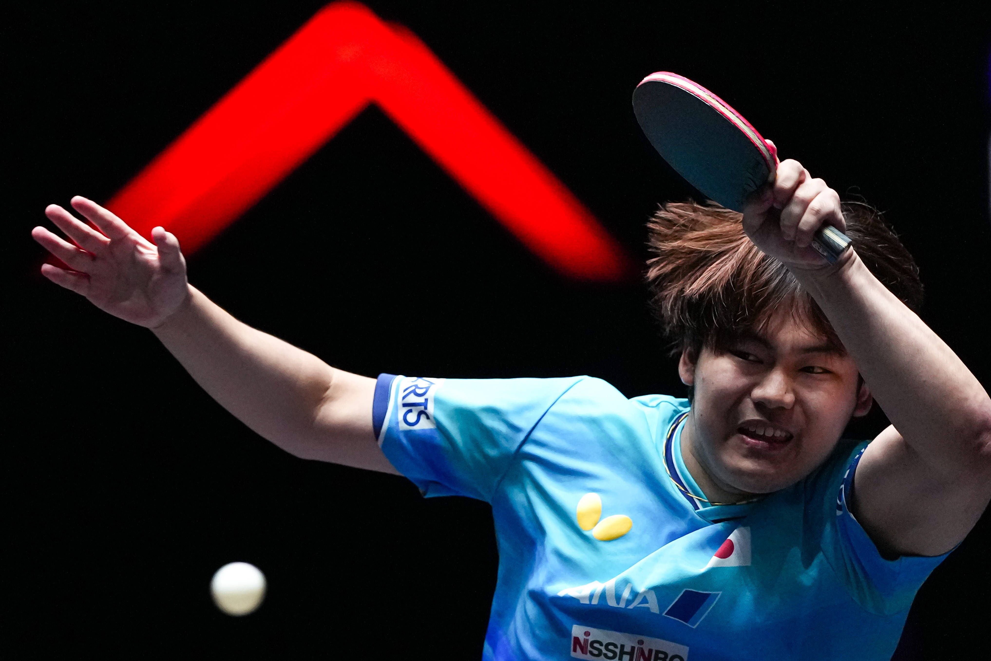Ein Tischtennisspieler im blauen Trikot schlägt konzentriert den Ball zurück.