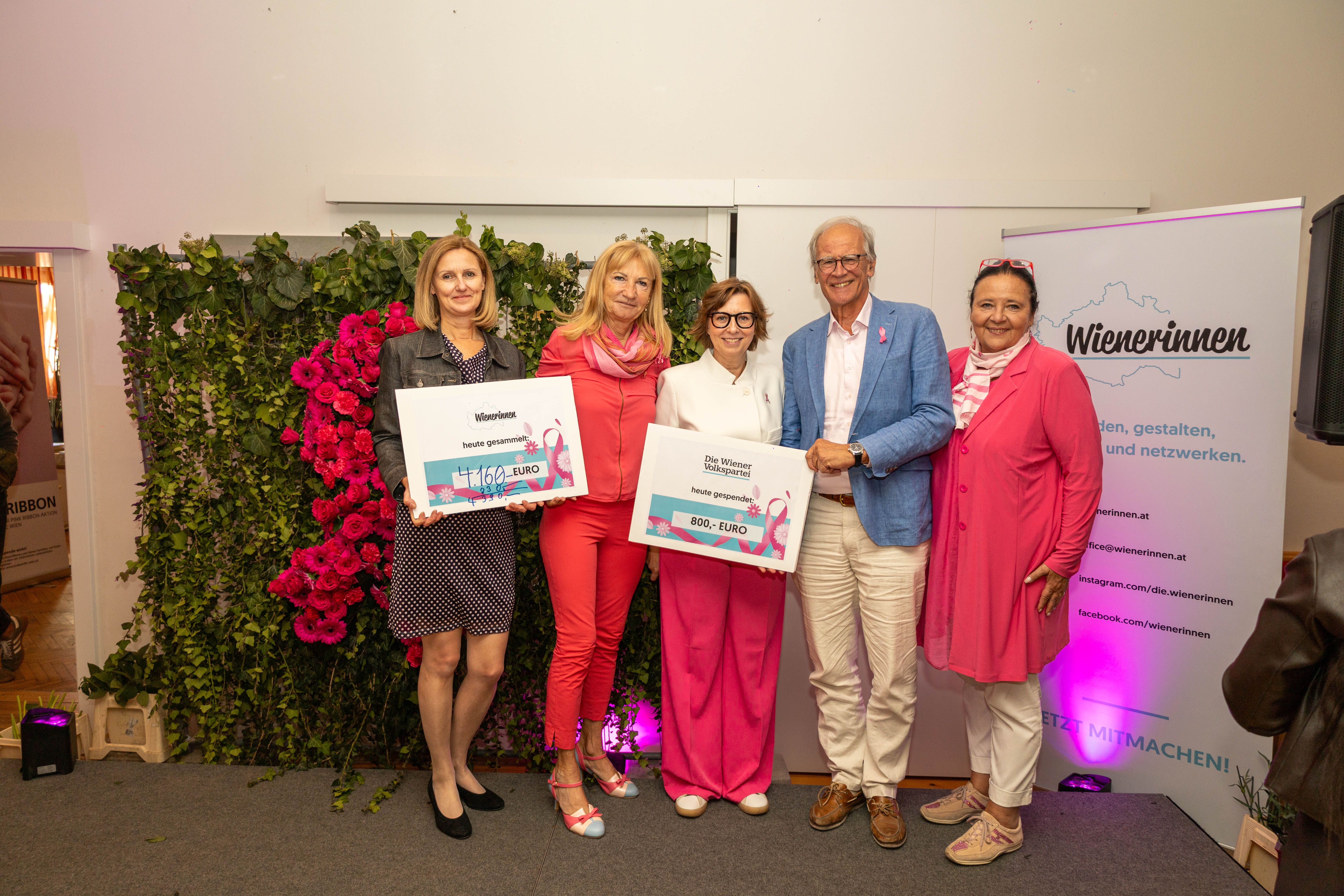 Fünf Personen posieren mit Spendenschecks beim Pink Ribbon Breakfast Club Event.