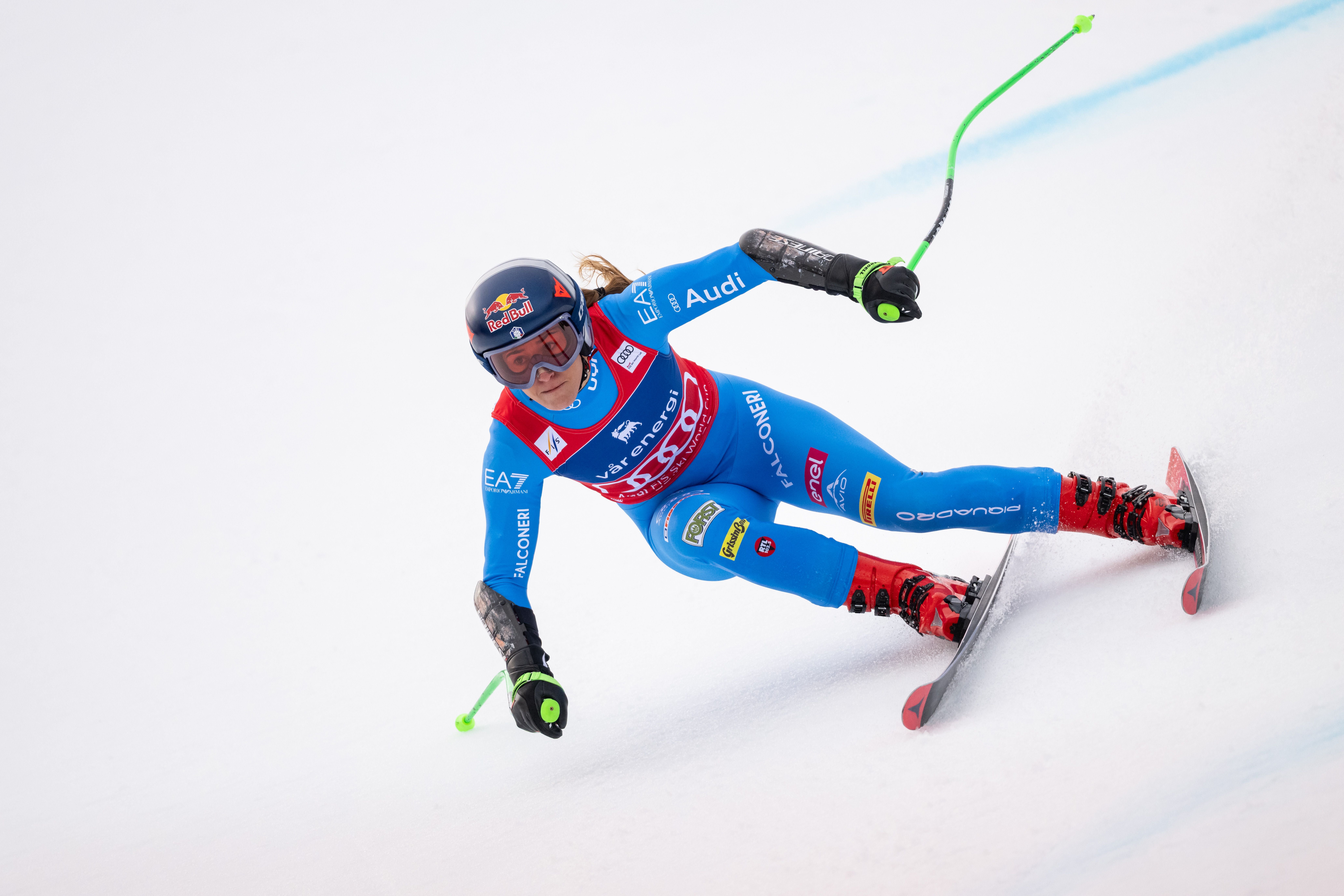 Skifahrerin in blauem Anzug fährt bei einem Super-G-Rennen eine Kurve auf Schnee.