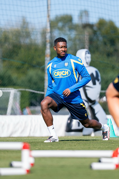 Ein Fußballspieler macht Aufwärmübungen auf einem Trainingsplatz im Freien.