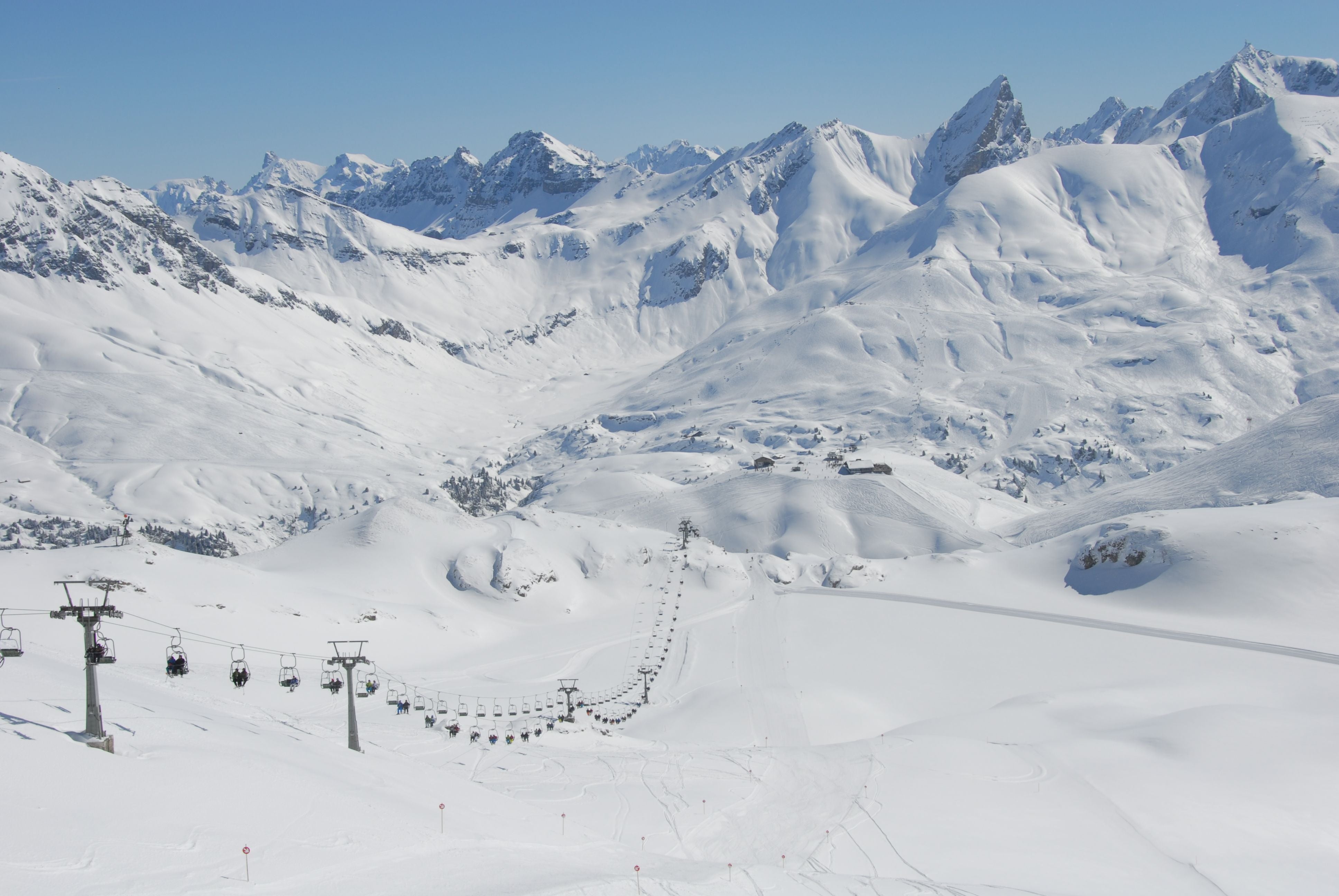 Schneebedeckte Berge mit Sessellift vom Zürser See zum Madloch in Arlberg, Österreich.