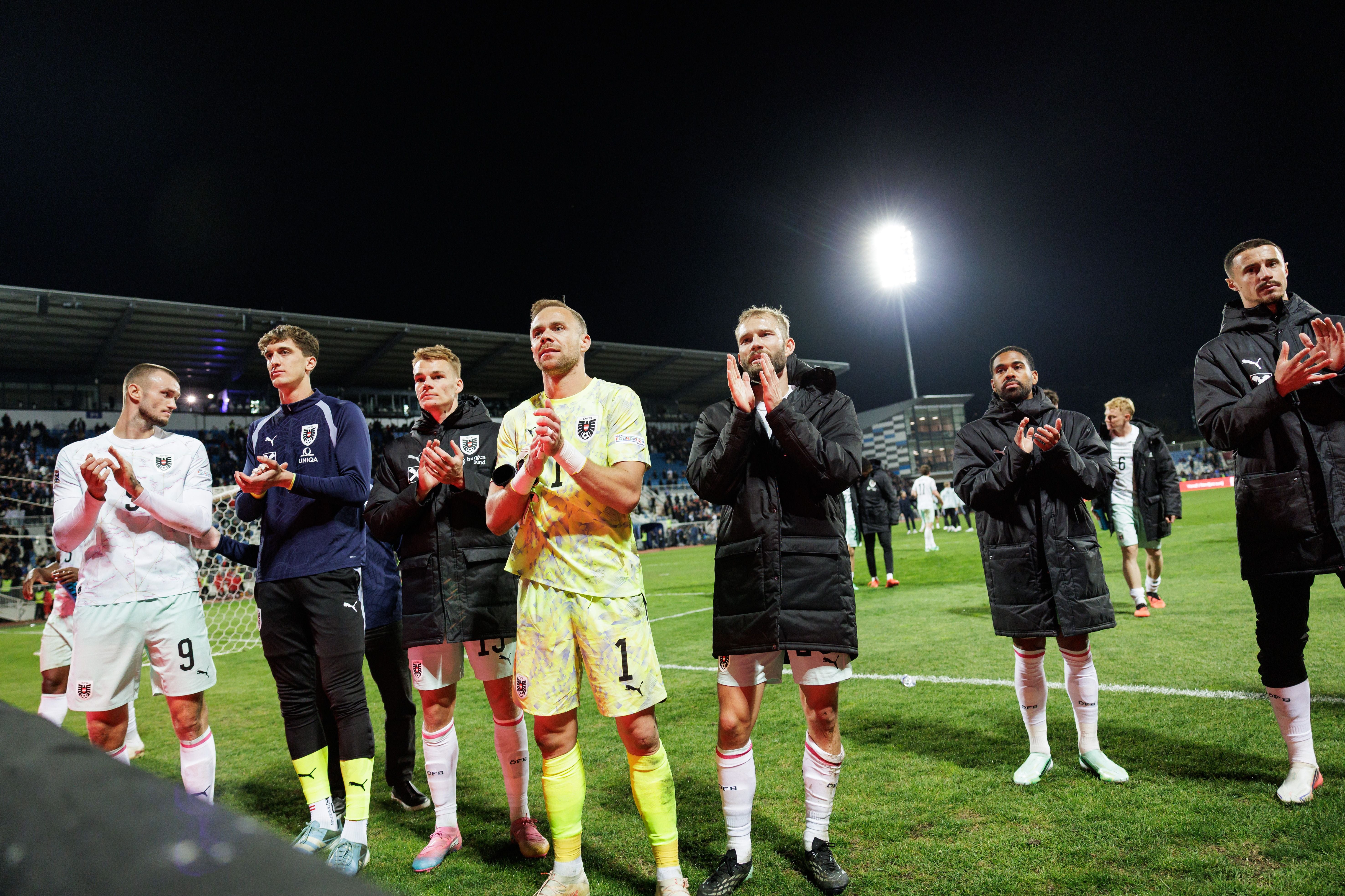 Österreichische Fußballspieler stehen auf dem Spielfeld und applaudieren nach dem Spiel in Kosovo.