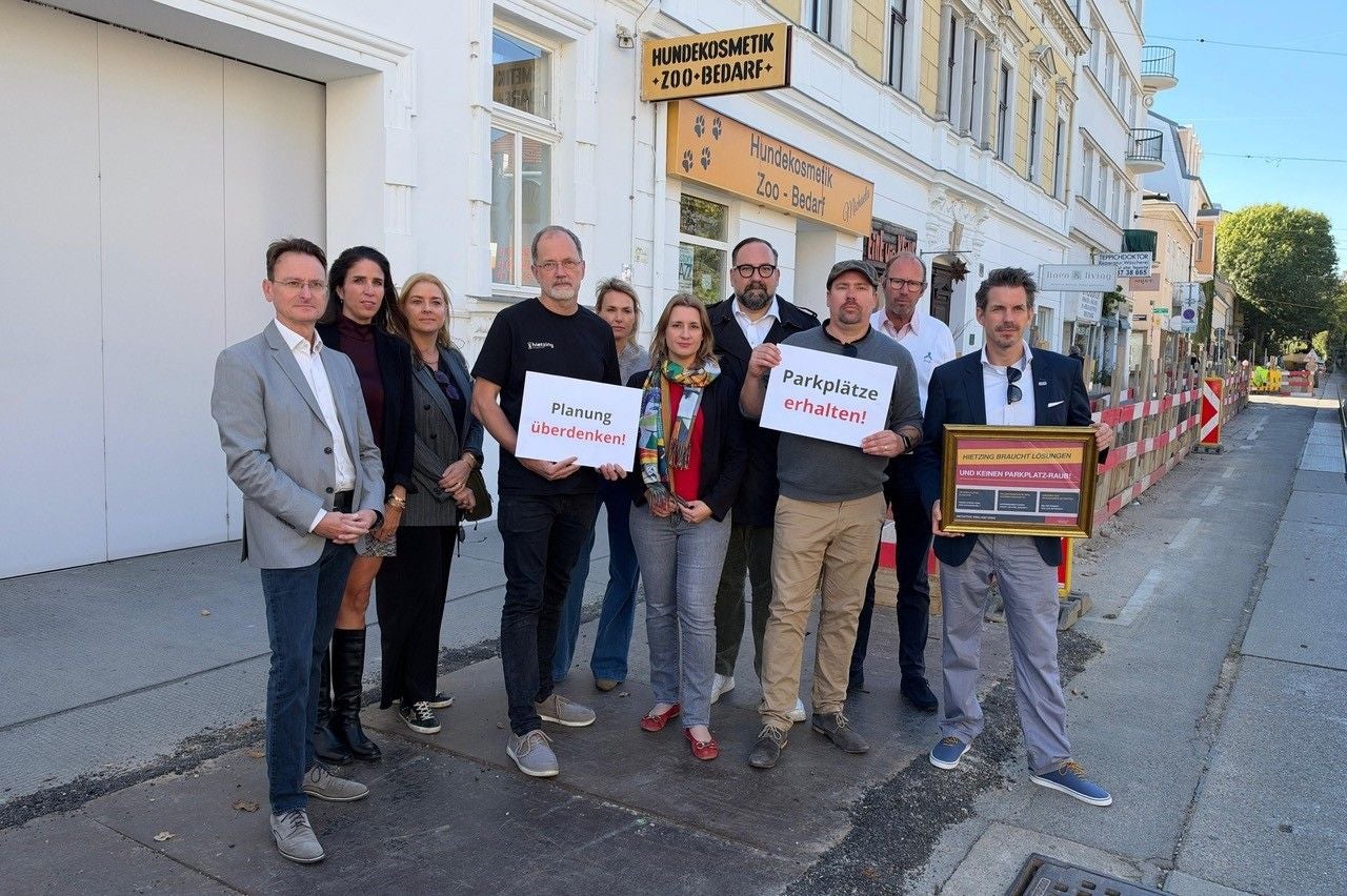 Eine Gruppe von Menschen protestiert mit Schildern für den Erhalt von Parkplätzen in Hietzing.
