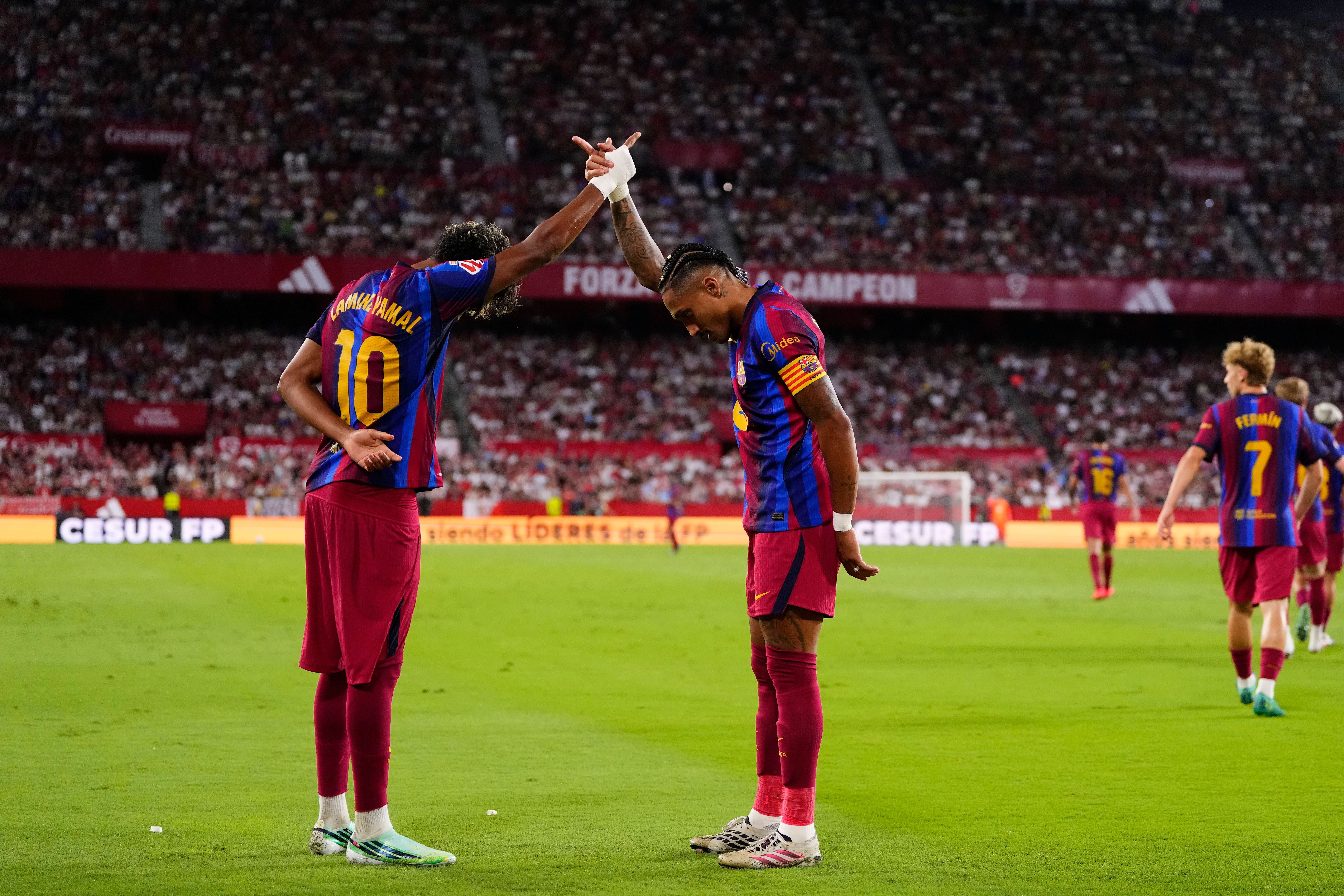 Zwei Barcelona-Spieler feiern ein Tor während eines Spiels im vollen Stadion.
