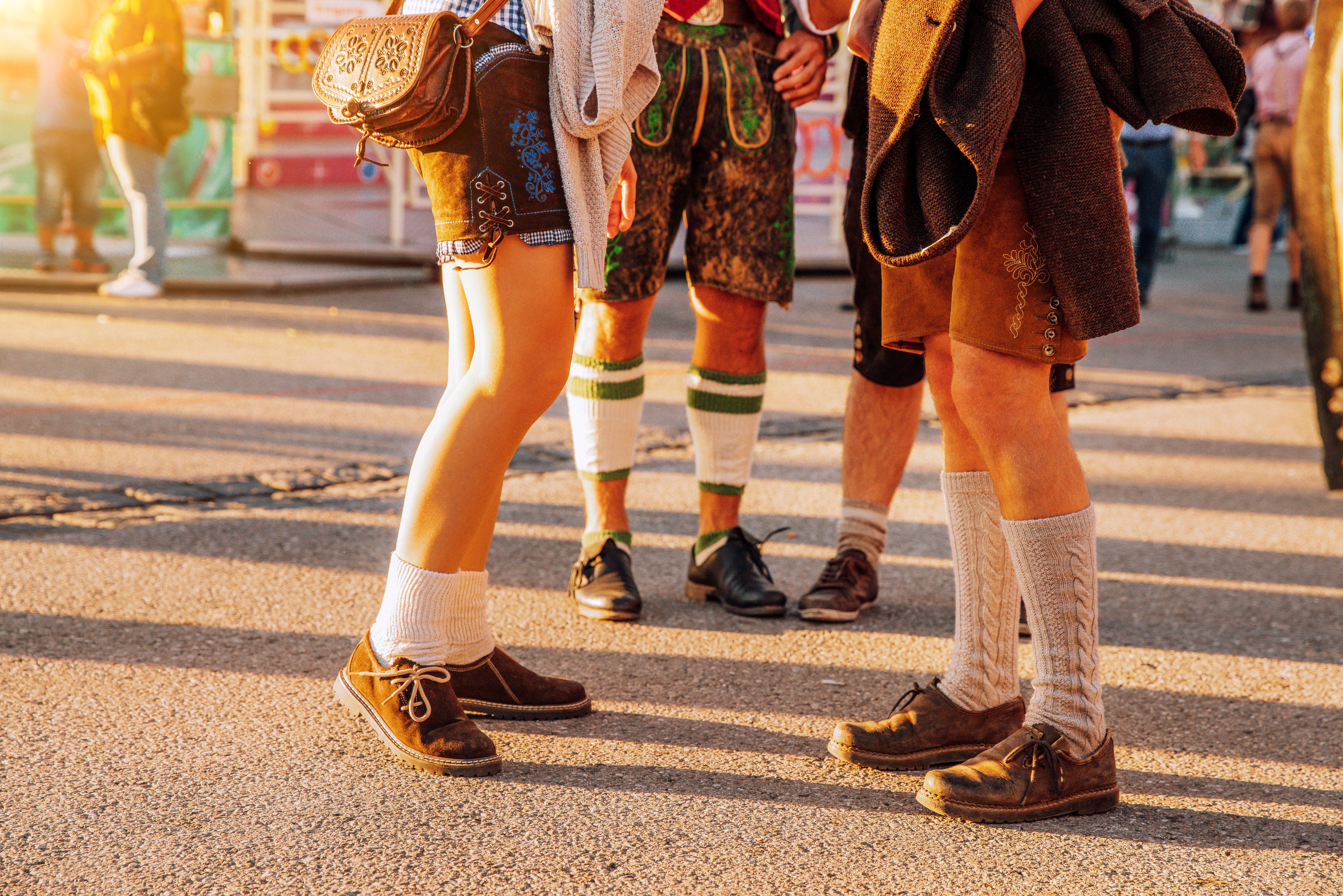 Menschen in traditioneller bayerischer Tracht, Lederhosen und Dirndl, auf einem Bierfest.