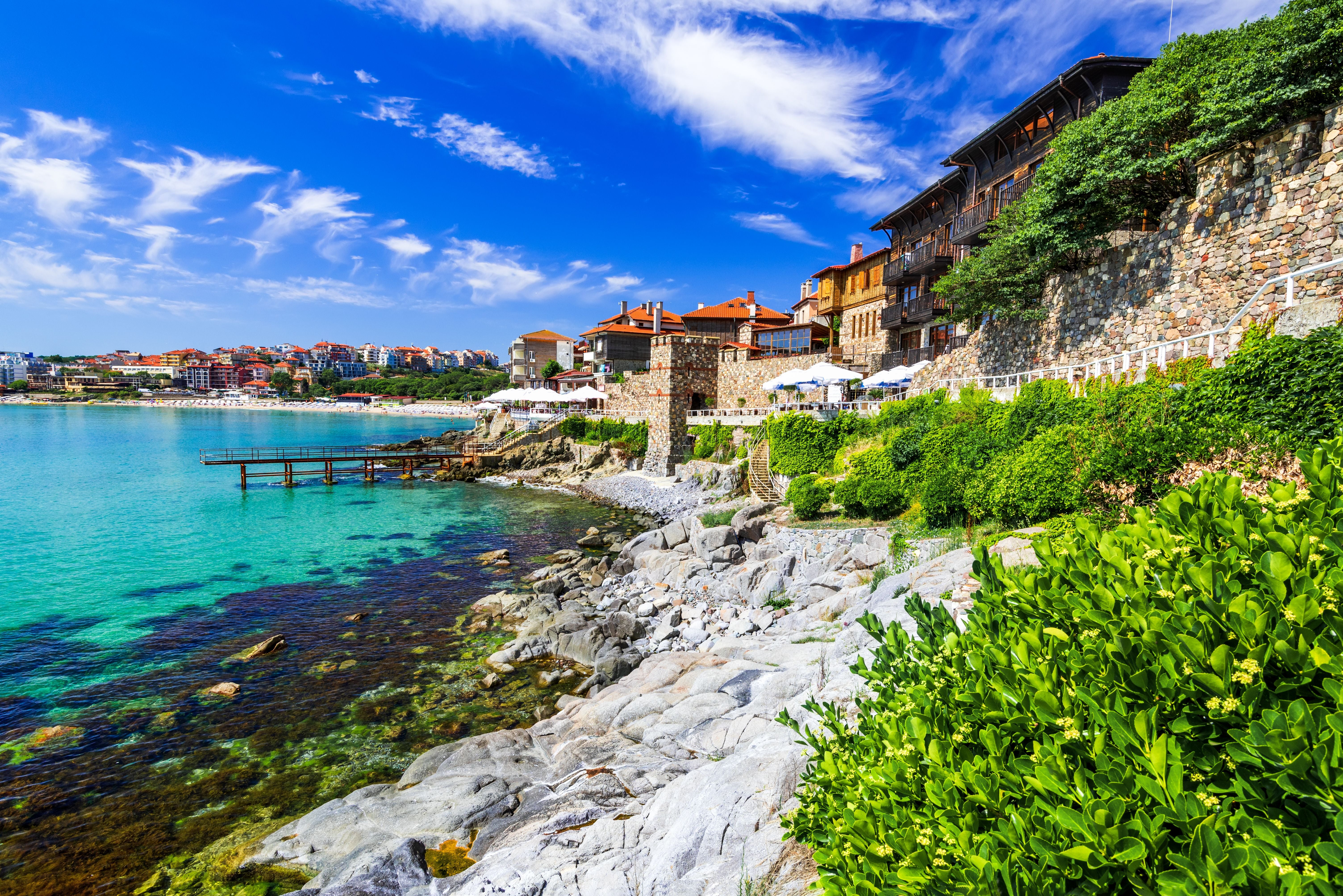 Alte Stadtmauern von Sozopol mit Blick auf das türkisblaue Schwarze Meer und grüne Vegetation.