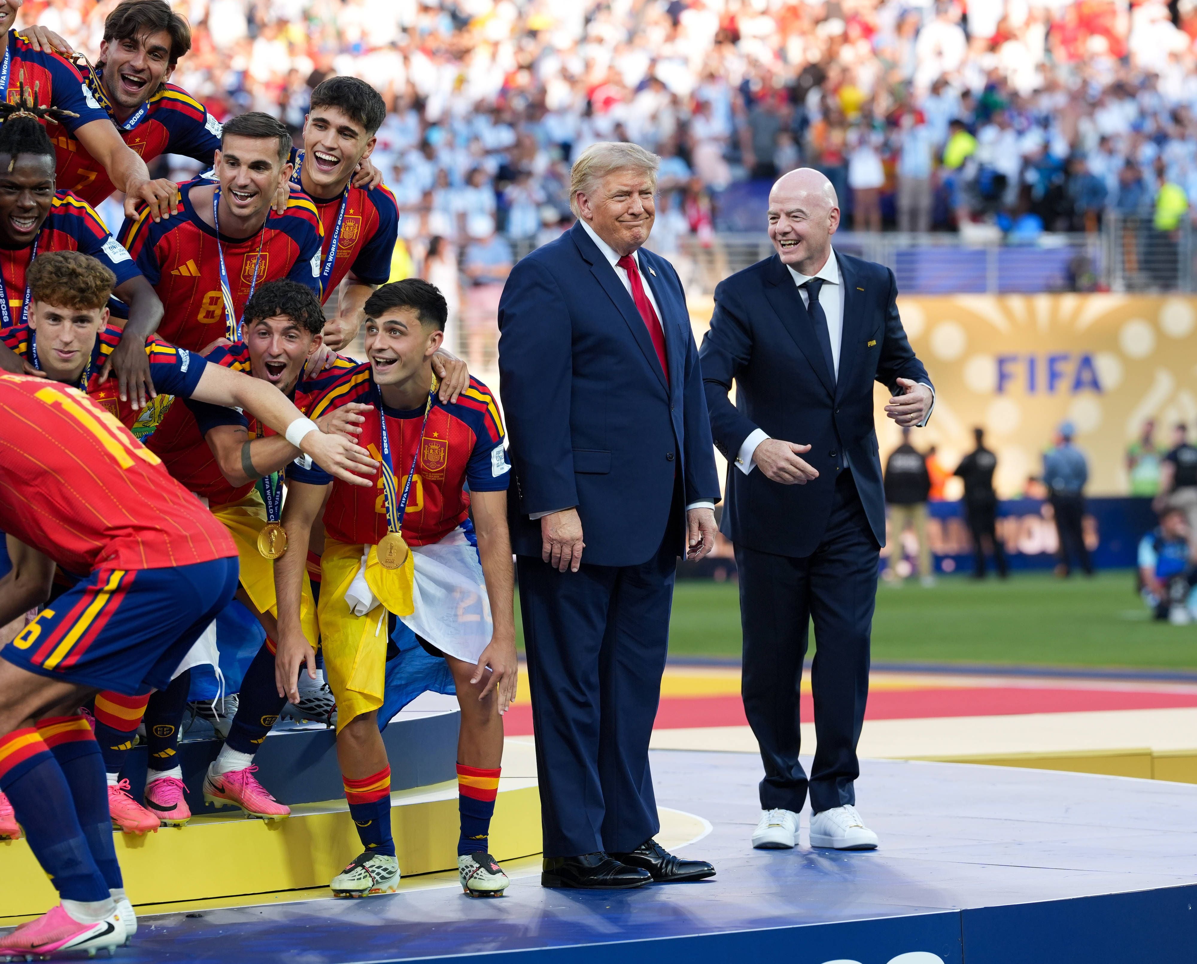 Donald Trump und Gianni Infantino stehen auf der Bühne, während Spaniens Fußballteam jubelt.