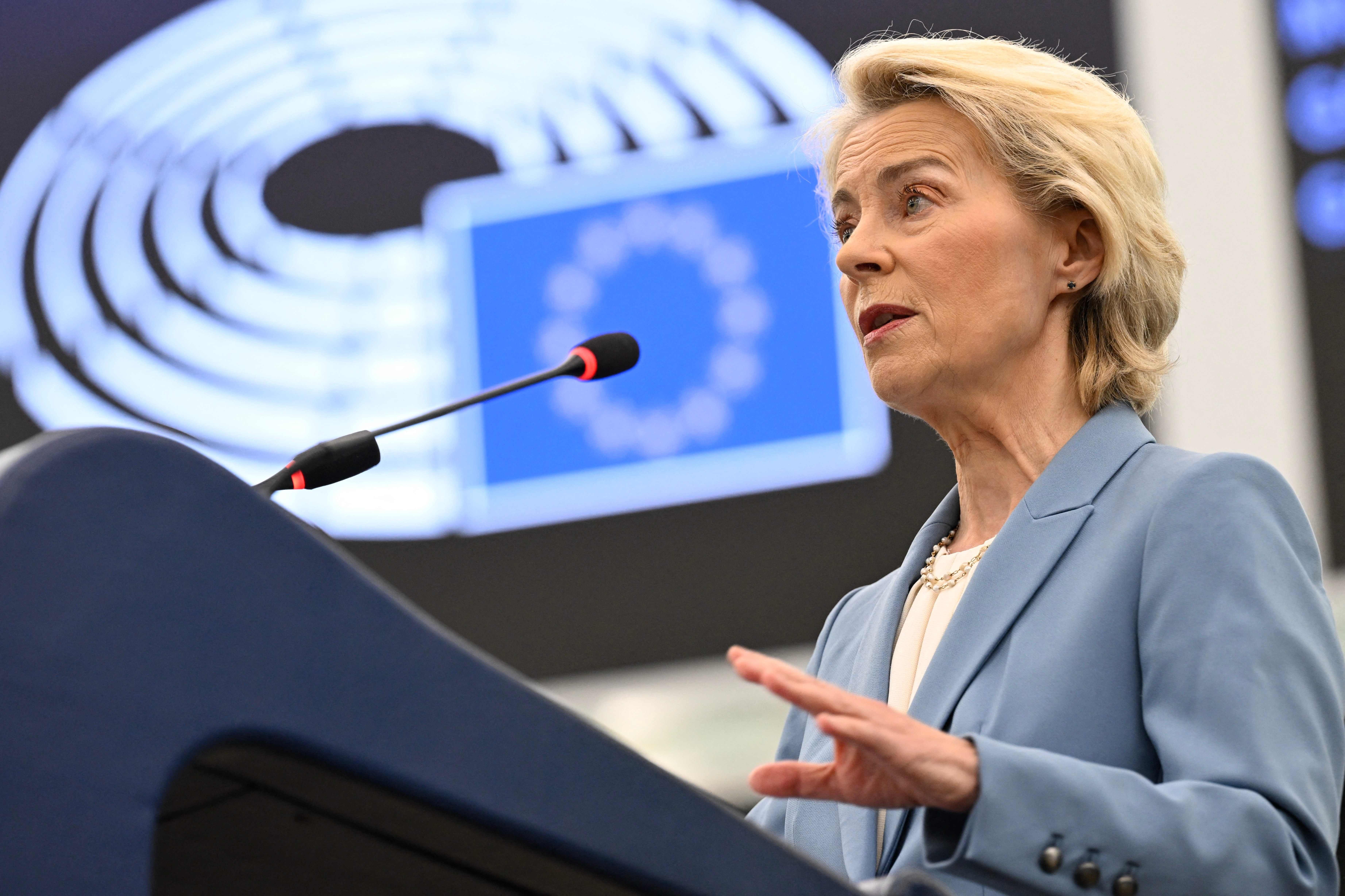 Frau am Rednerpult spricht vor dem EU-Parlament, im Hintergrund ein EU-Sternenkreis.