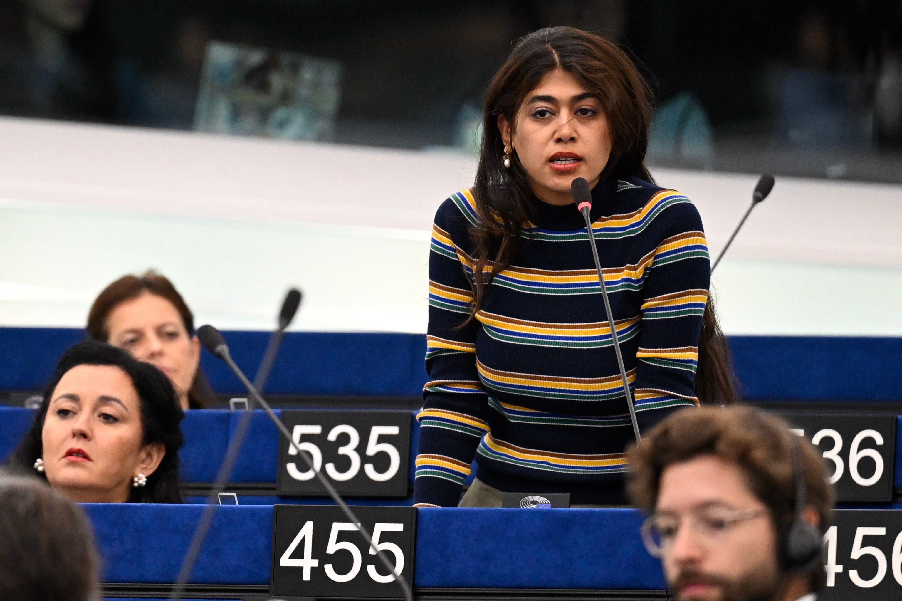 Eine Frau spricht am Mikrofon im Europäischen Parlament, umgeben von weiteren Anwesenden.