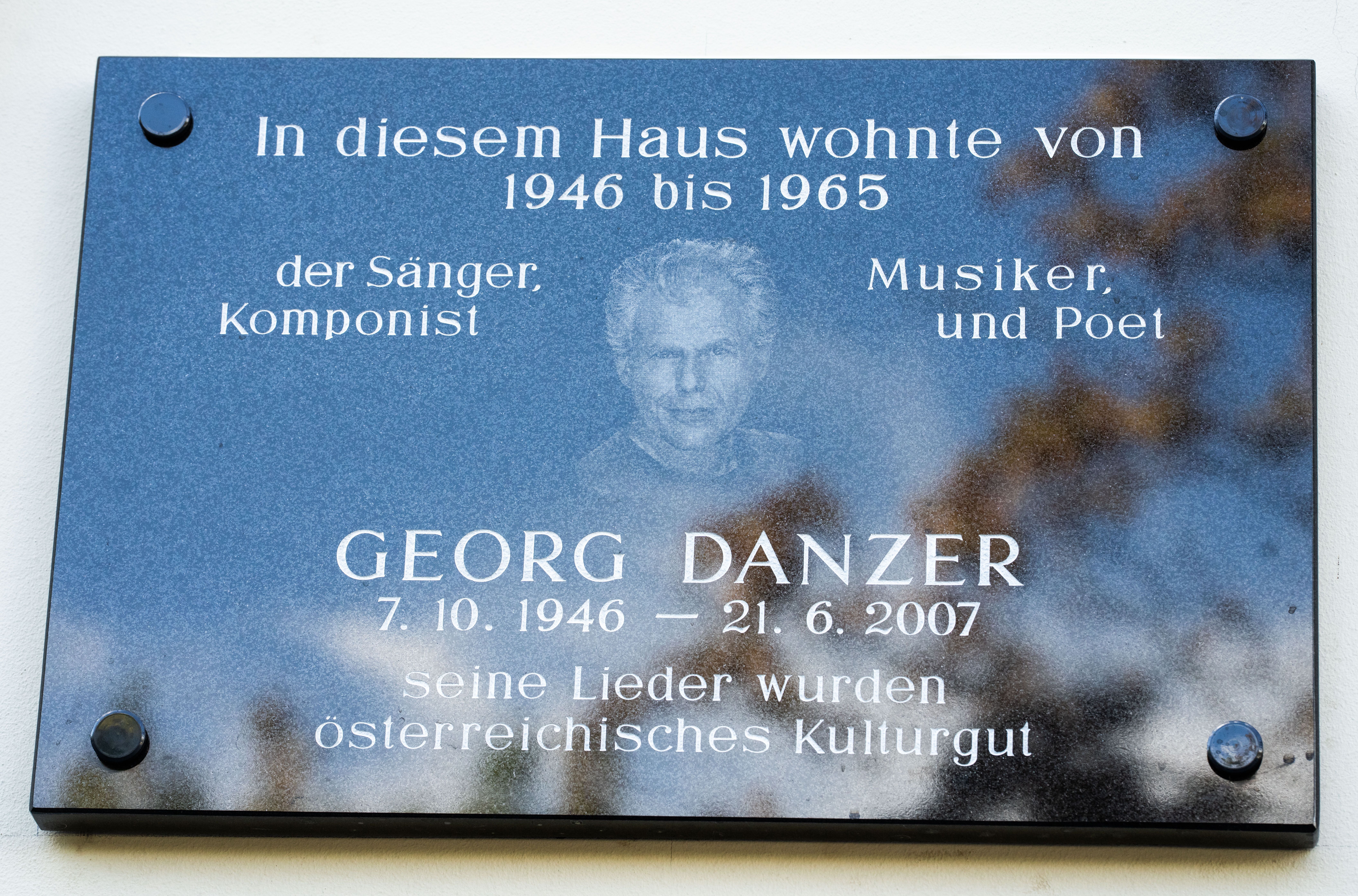 Gedenktafel für Georg Danzer mit Inschrift und Porträt am Haus in Wien.
