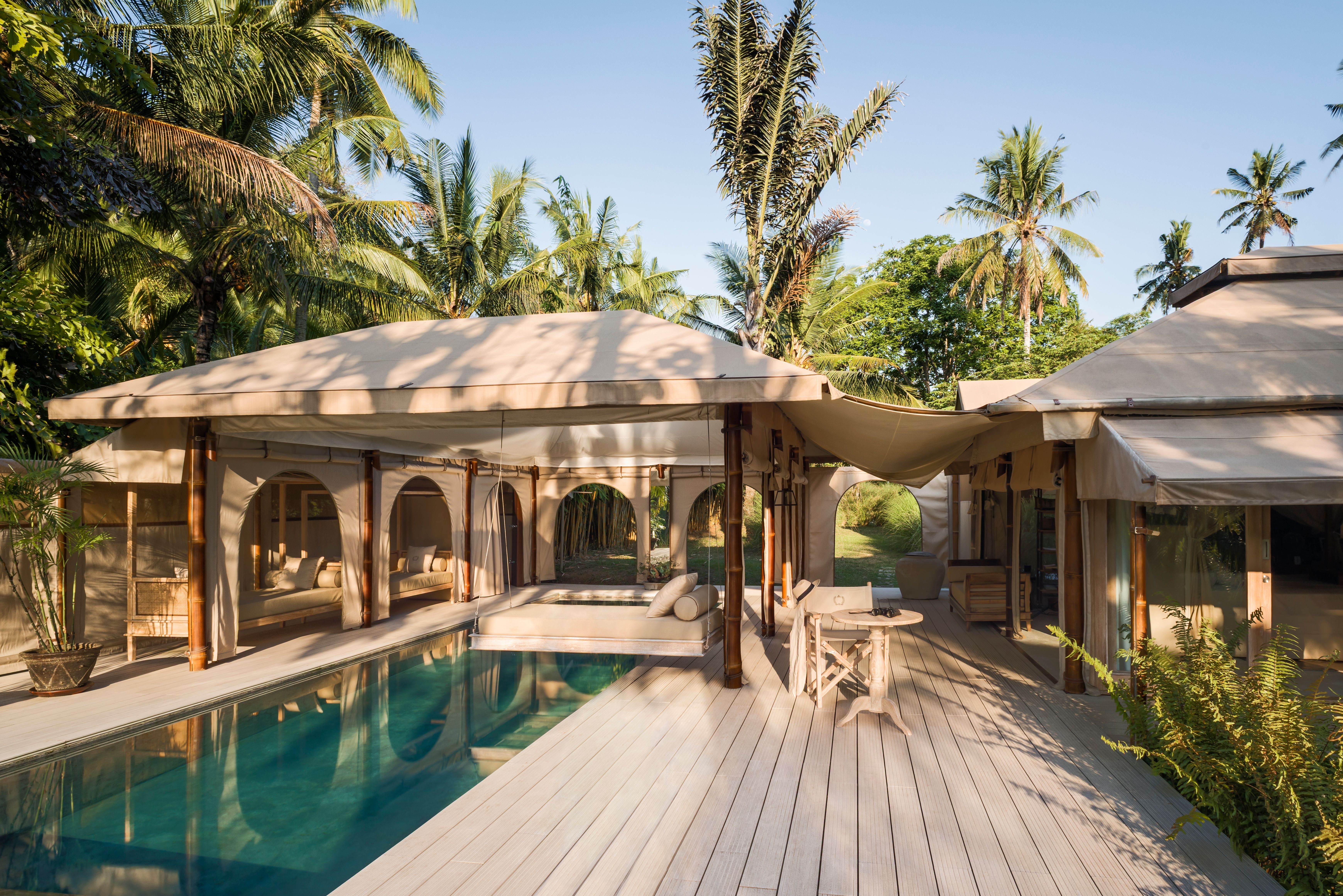 Luxuriöse Zeltvilla mit Pool inmitten von Palmen und üppiger Vegetation in Bali, Indonesien.