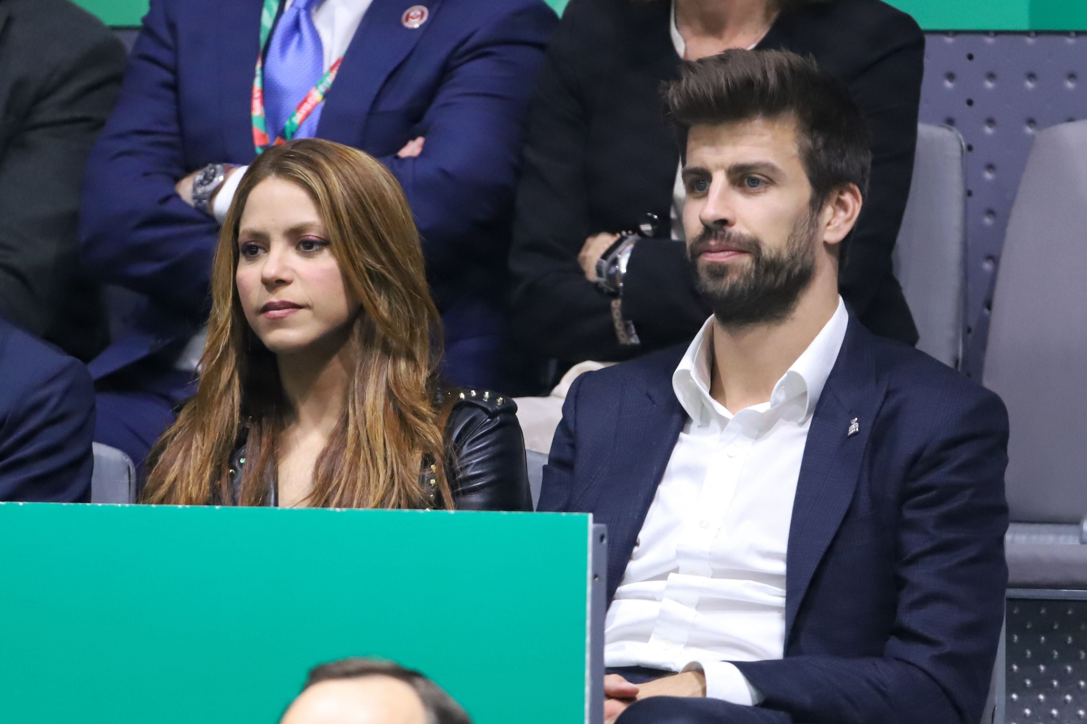 Eine Frau und ein Mann sitzen nebeneinander bei einem Sportevent in einer Arena.