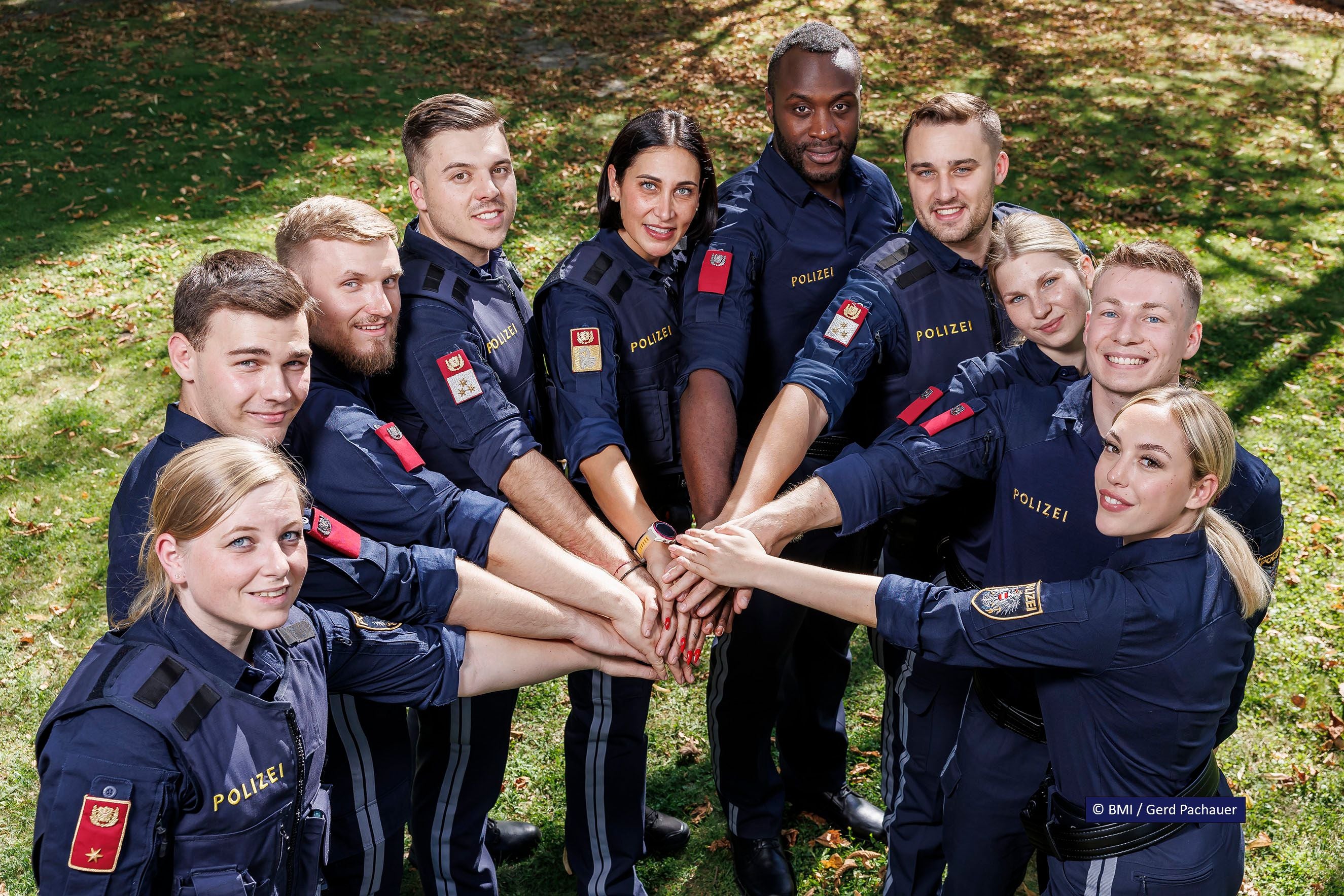 Eine Gruppe Polizistinnen und Polizisten steht im Kreis und legt die Hände übereinander.