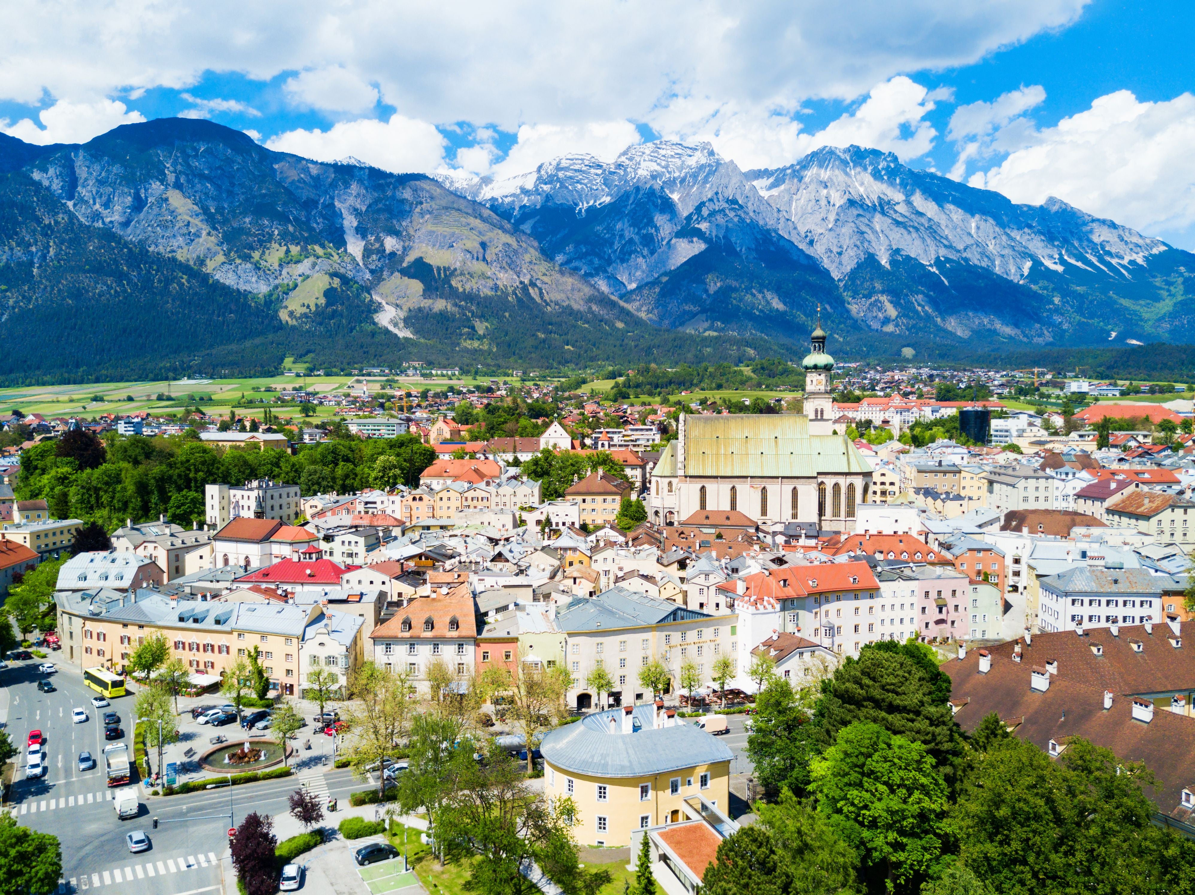Panoramablick auf Hall in Tirol mit der Pfarrkirche St. Nikolaus und Bergen im Hintergrund.
