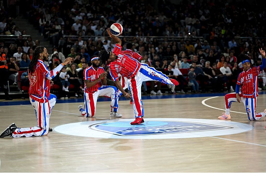 Die Harlem Globetrotters führen eine Basketball-Show in einer vollen Sporthalle auf.