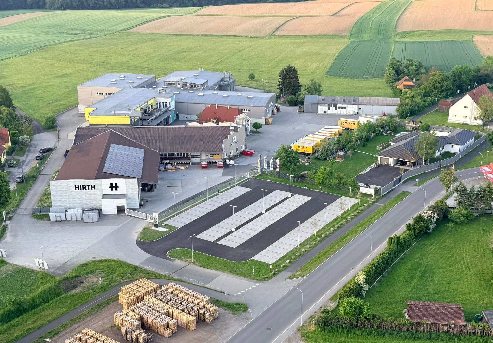 Luftaufnahme des Firmengeländes von Hirth in Groß-Siegharts mit Parkplätzen und Hallen.