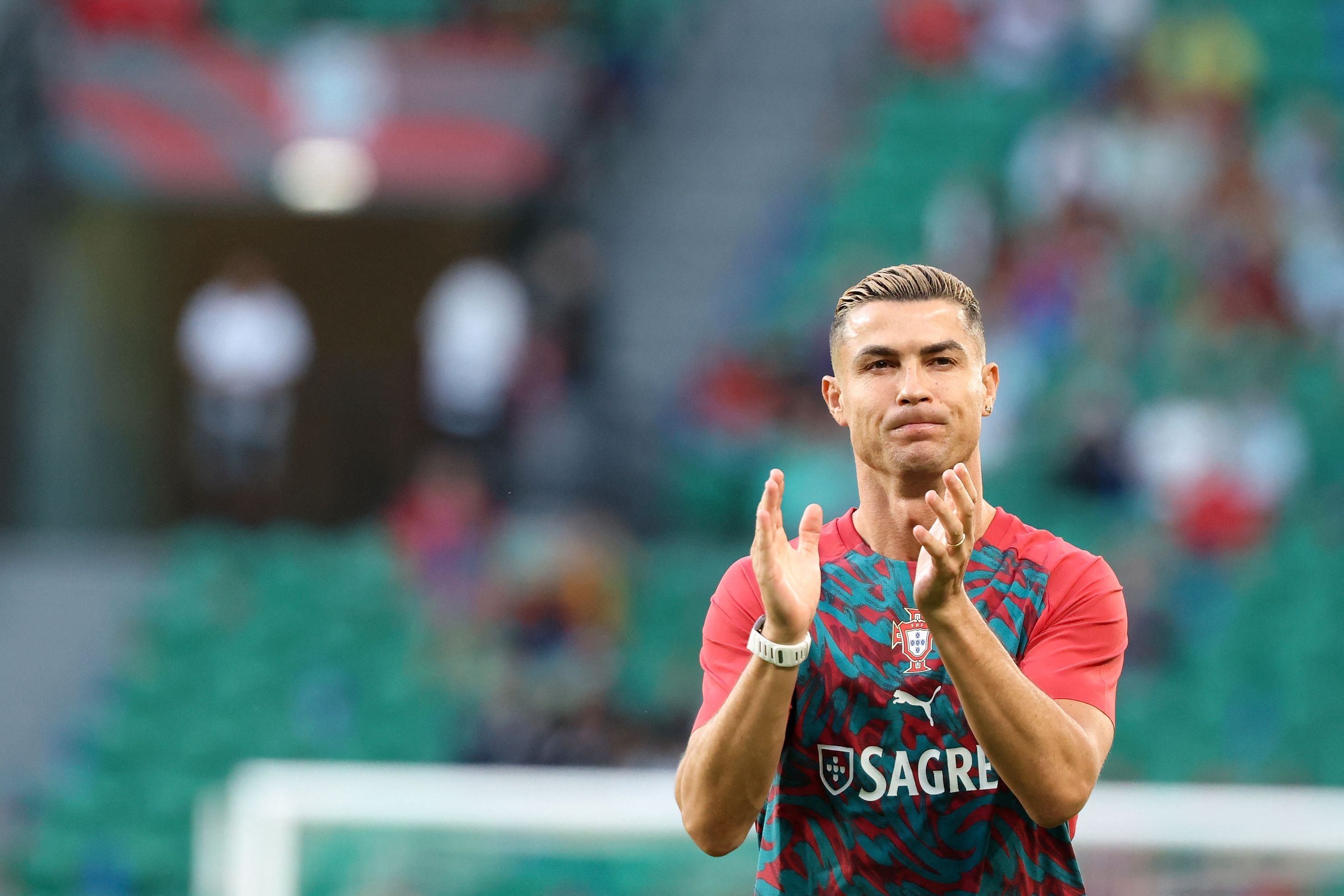 Ein Fußballspieler im Portugal-Trikot klatscht während des Aufwärmens im Stadion.