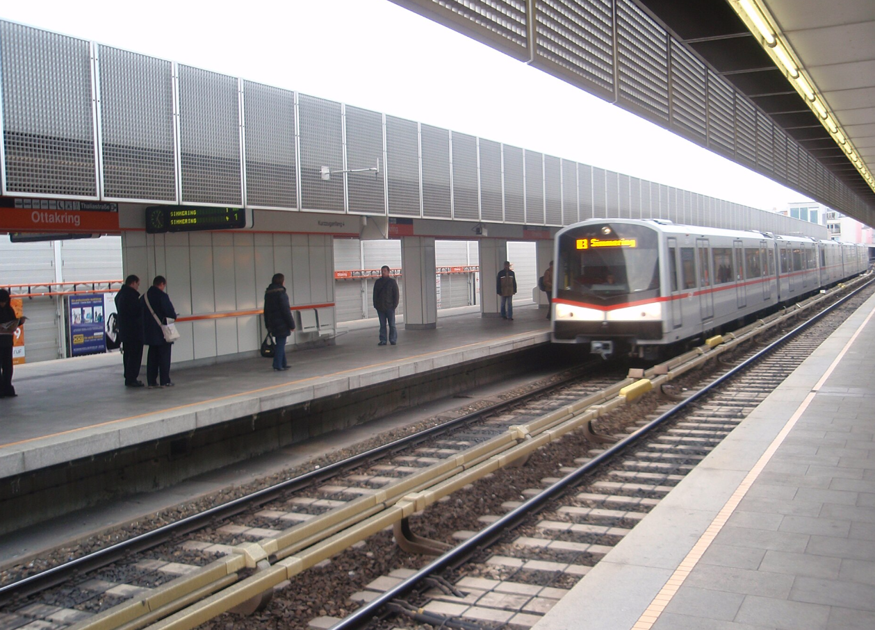 Eine U-Bahn fährt in die Station Ottakring ein, mehrere Personen warten am Bahnsteig.