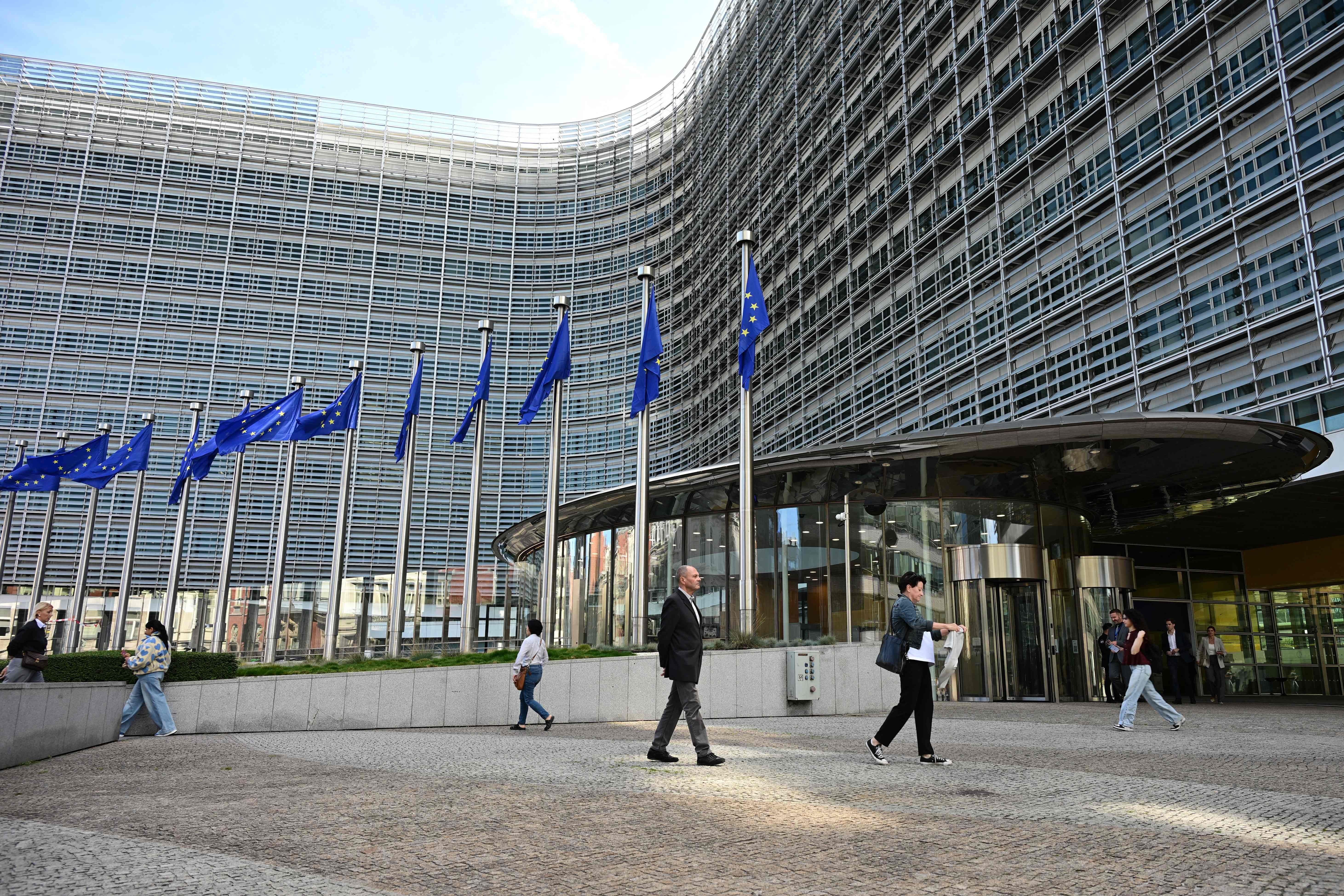 Menschen gehen vor dem Berlaymont-Gebäude der EU-Kommission in Brüssel entlang.