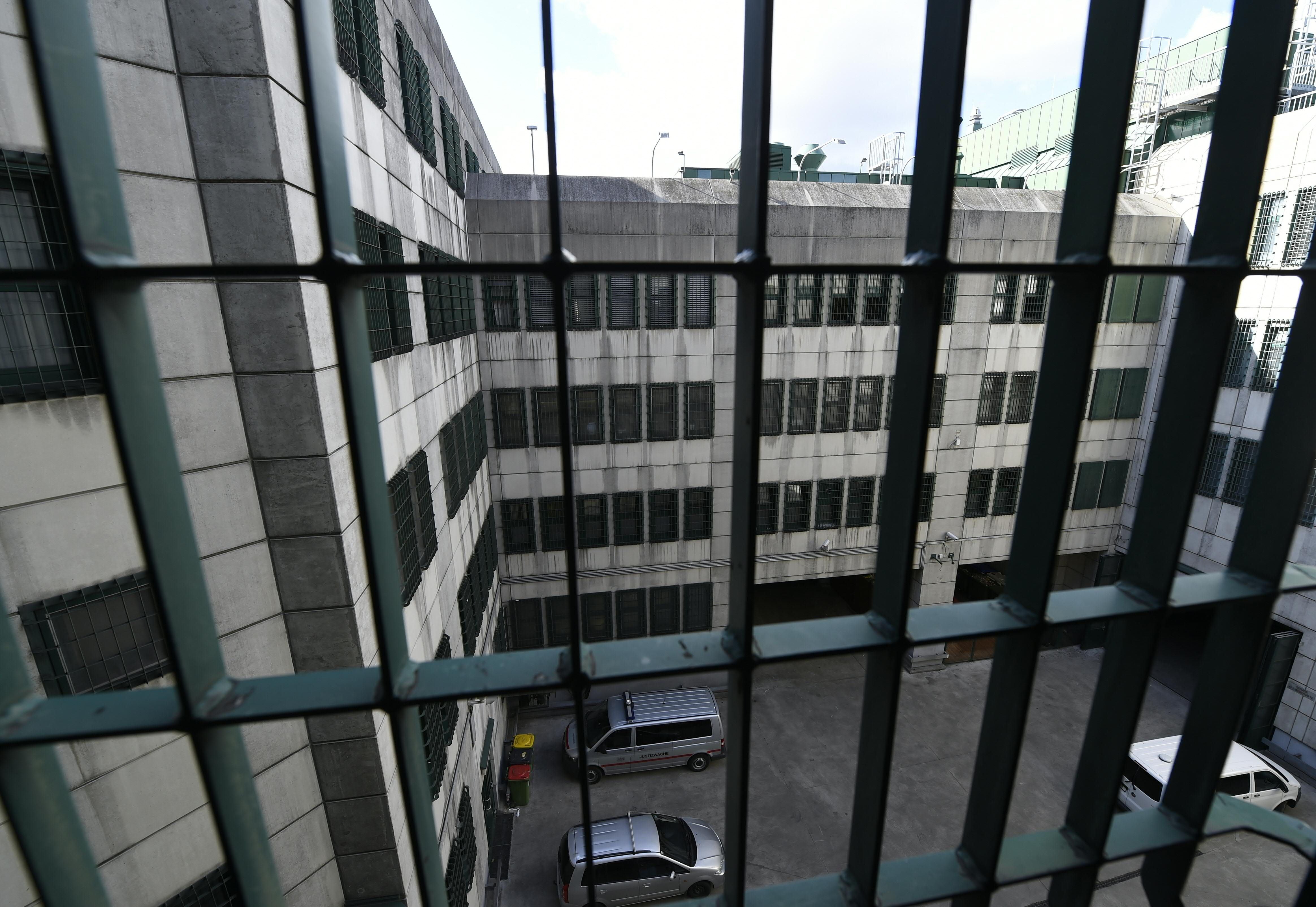 Blick durch Gitterstäbe auf den Hof und Gebäude der Justizanstalt Josefstadt in Wien.