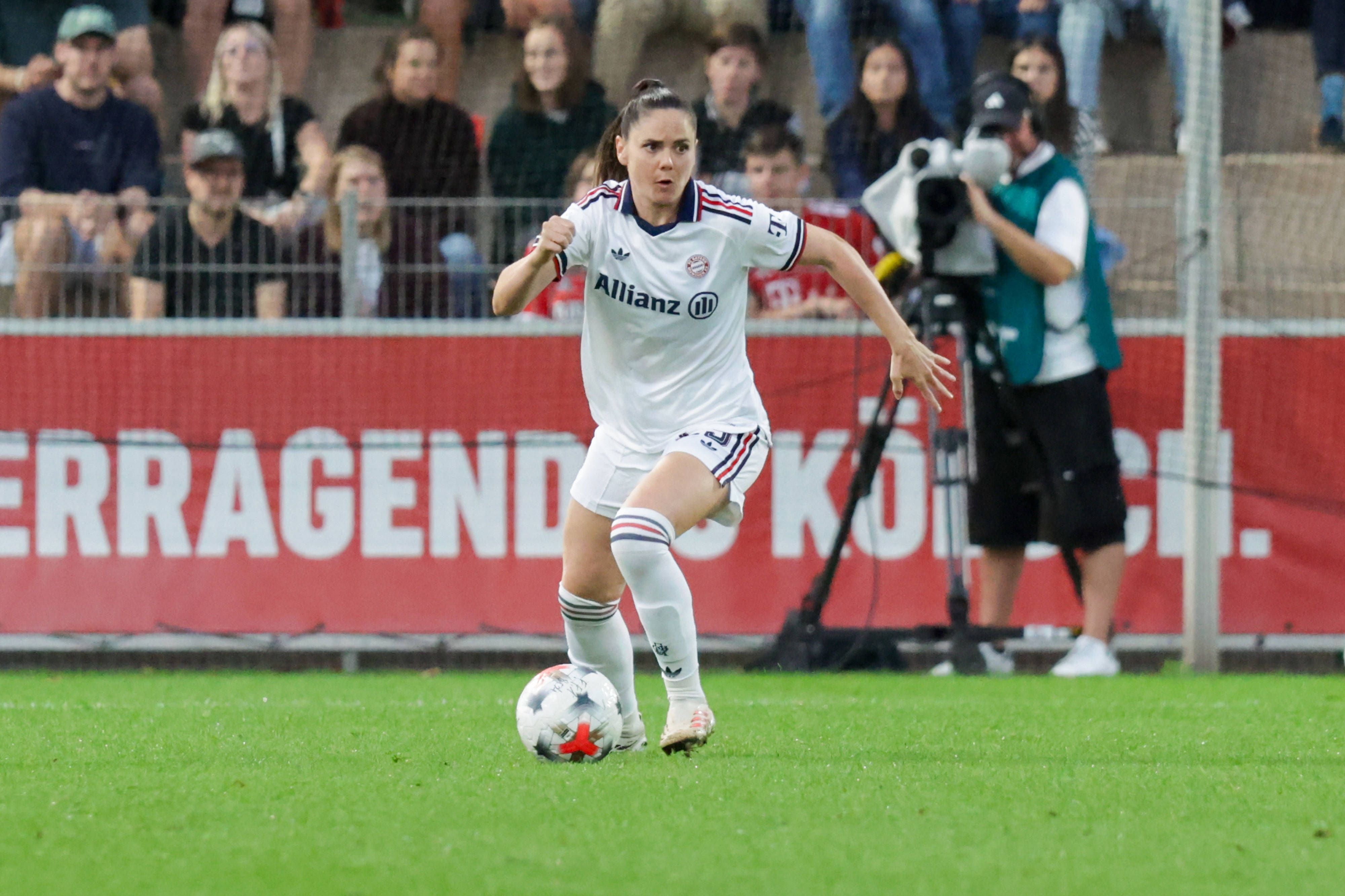 Sarah Zadrazil sprintet im weißen Bayern-München-Trikot bei einem Spiel mit dem Ball am Fuß übers Feld.