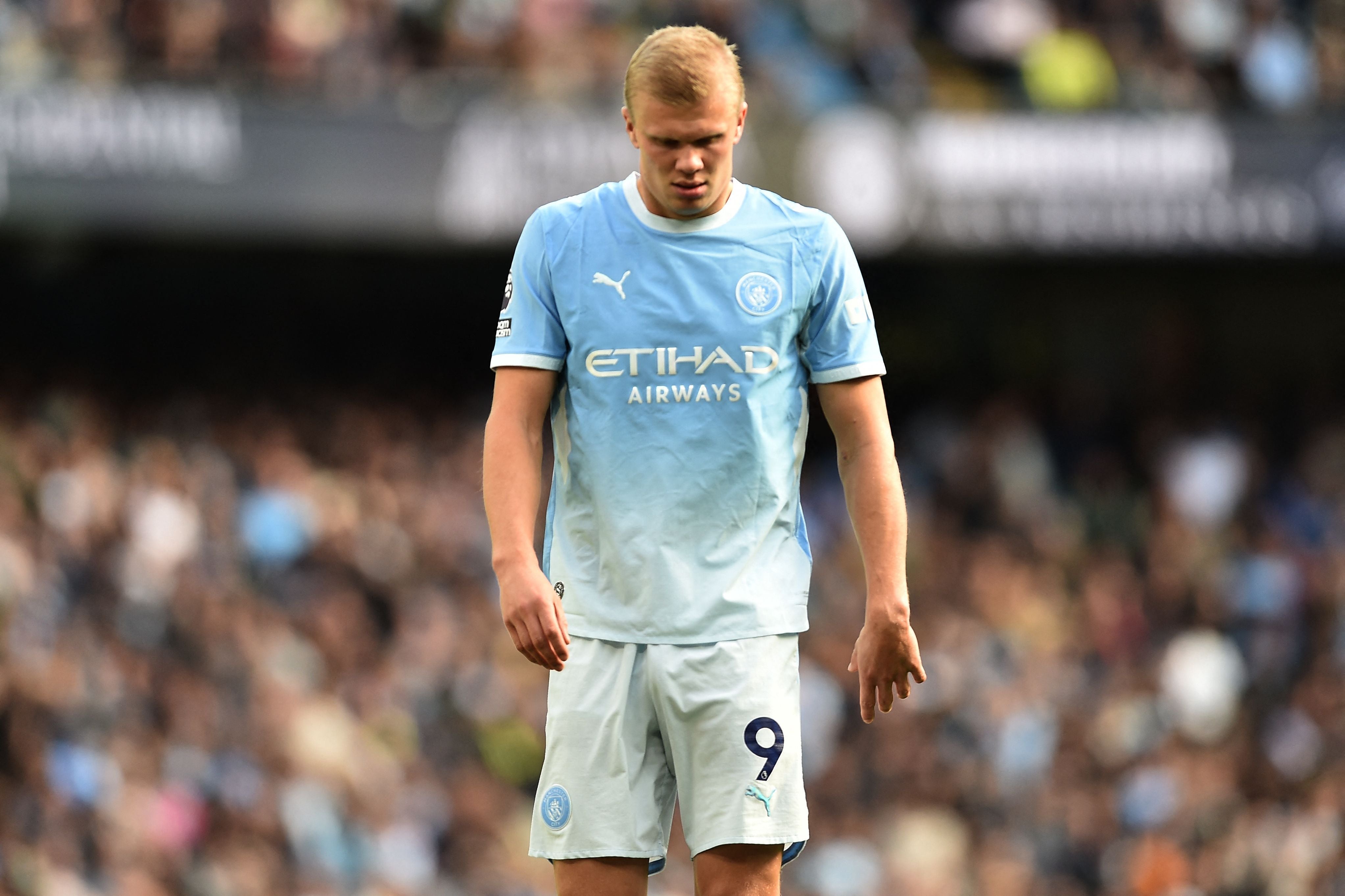 Ein Manchester City-Spieler im himmelblauen Trikot blickt nach unten auf dem Spielfeld.
