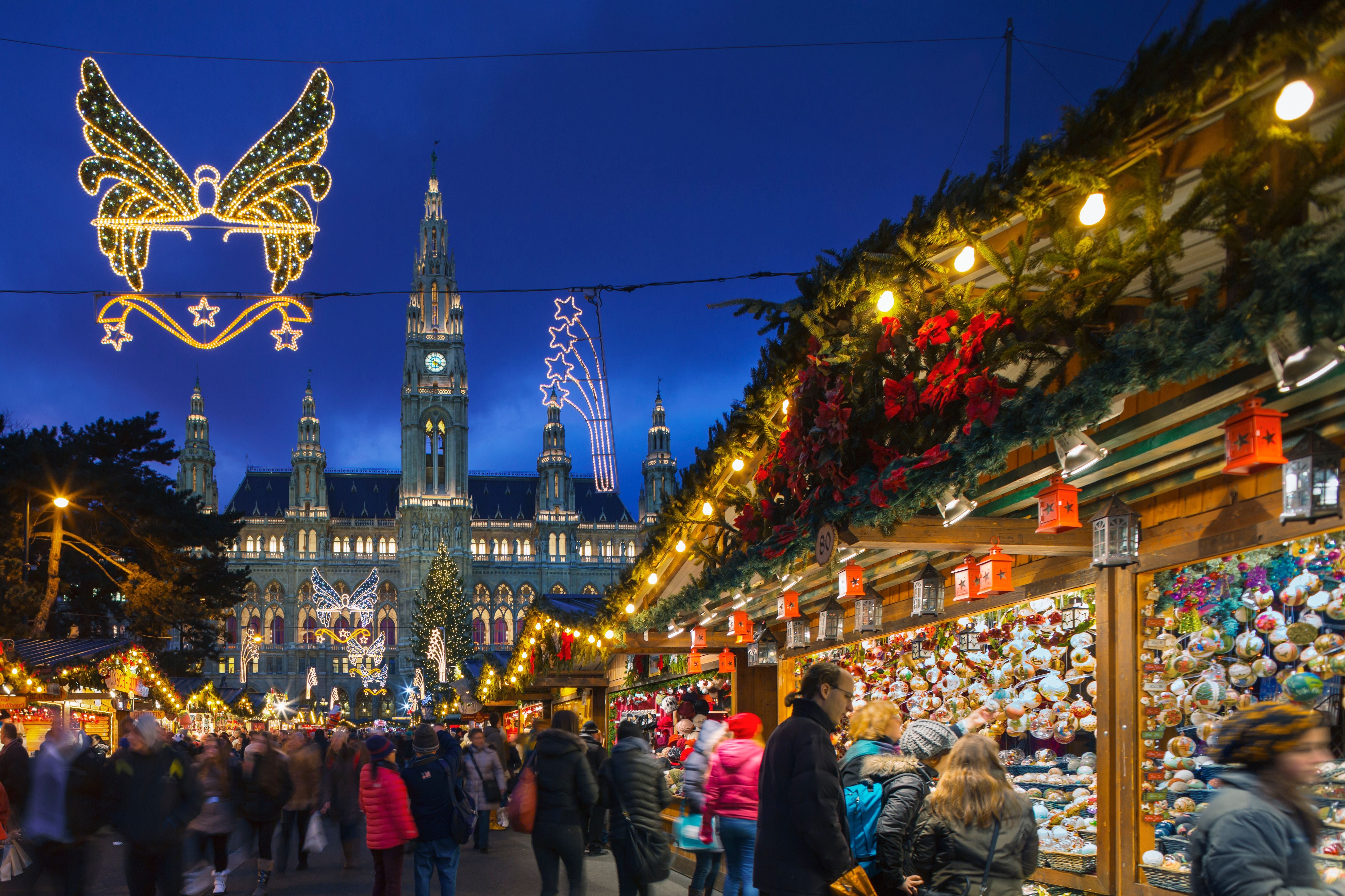 Weihnachtsmarkt am Wiener Rathausplatz mit festlichen Lichtern und geschmückten Marktständen.