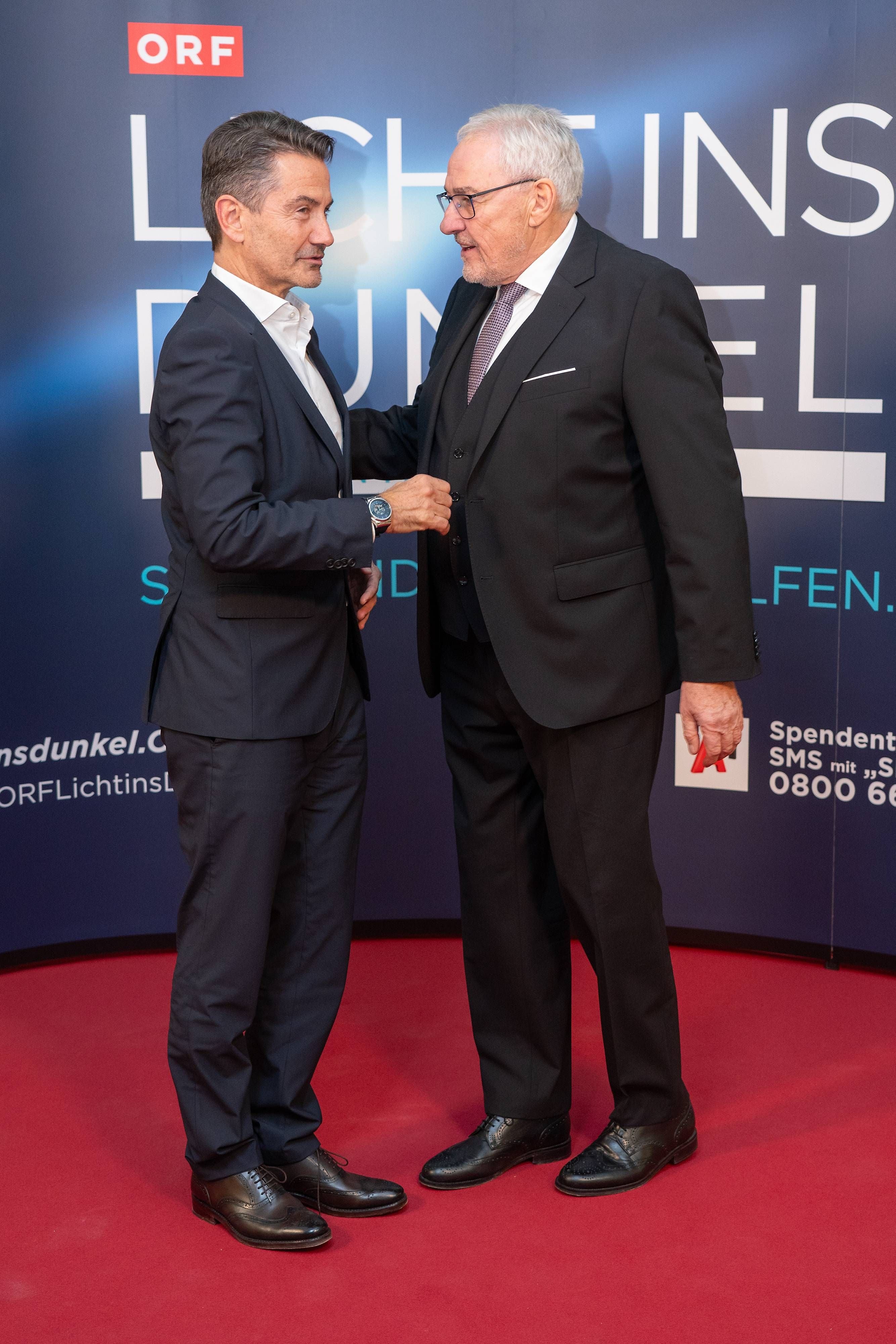 Zwei Männer im Anzug begrüßen sich auf dem roten Teppich bei der ORF Licht ins Dunkel Gala.