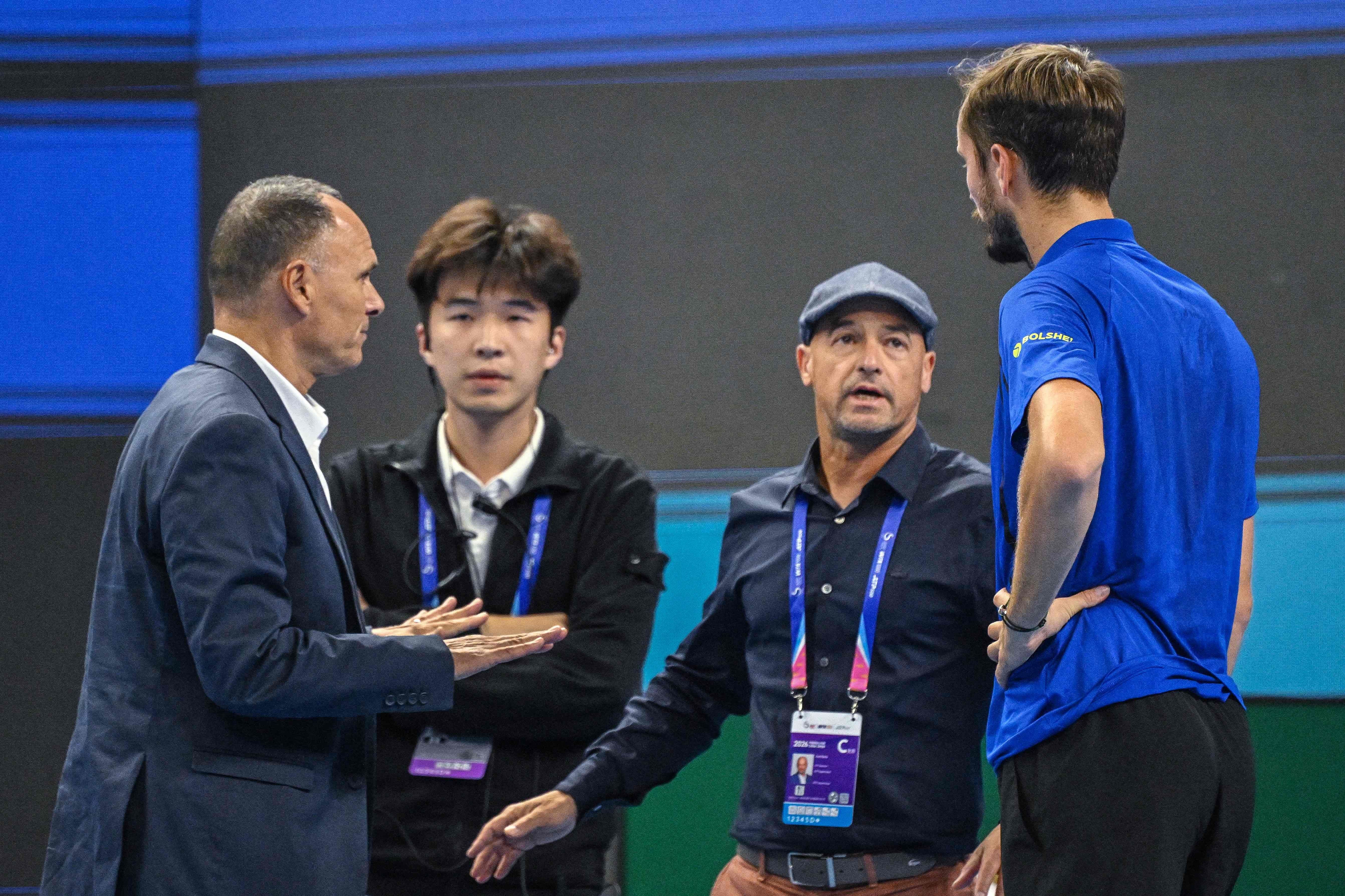 Vier Männer diskutieren während eines Tennisturniers auf dem Spielfeld.