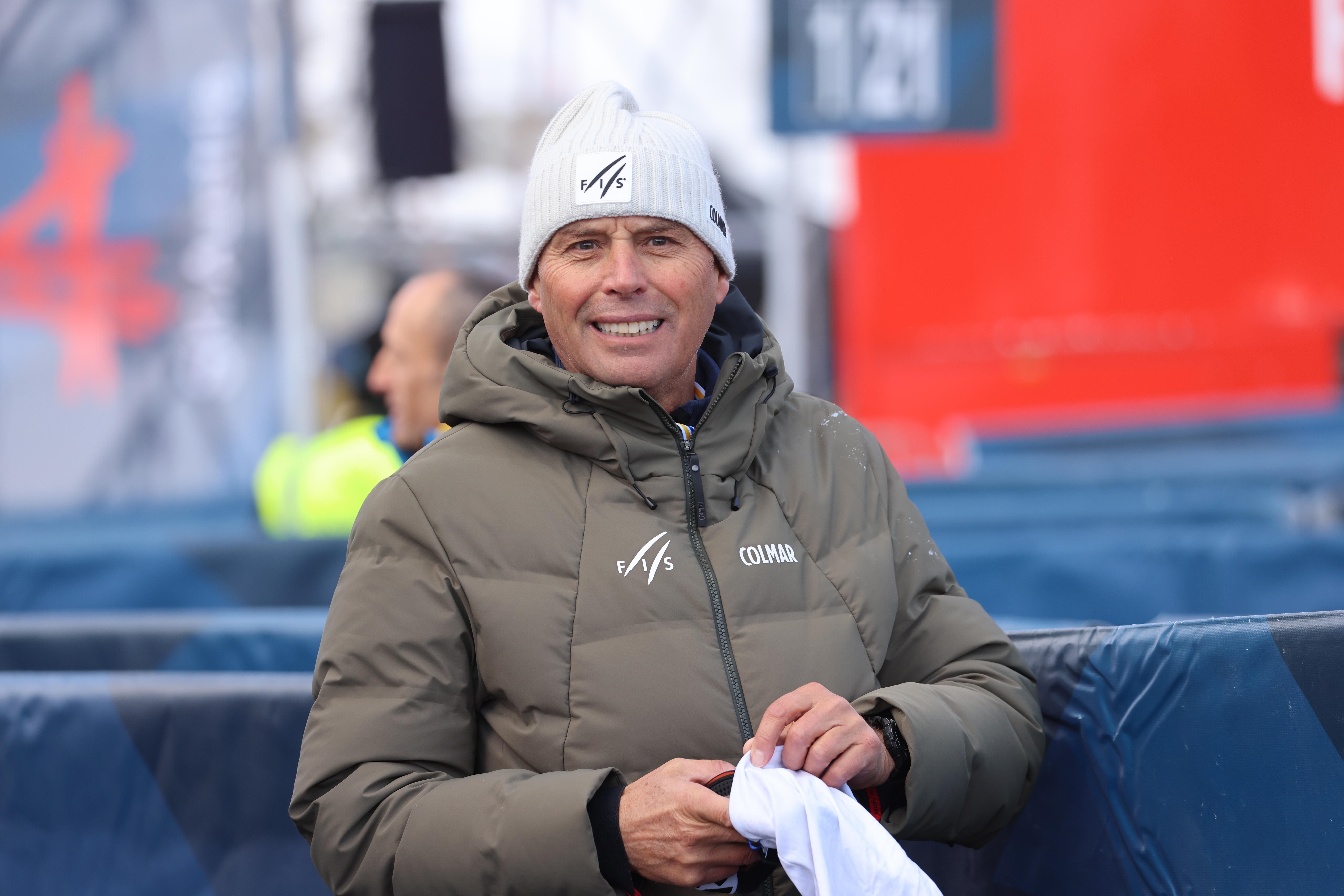 Ein Mann in Winterkleidung lächelt bei einem Ski-Event im Freien in die Kamera.