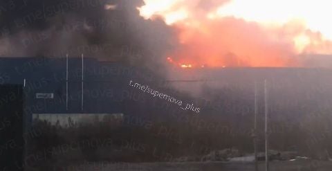 Großbrand mit starker Rauchentwicklung auf einem Industriegebäude bei Tageslicht.