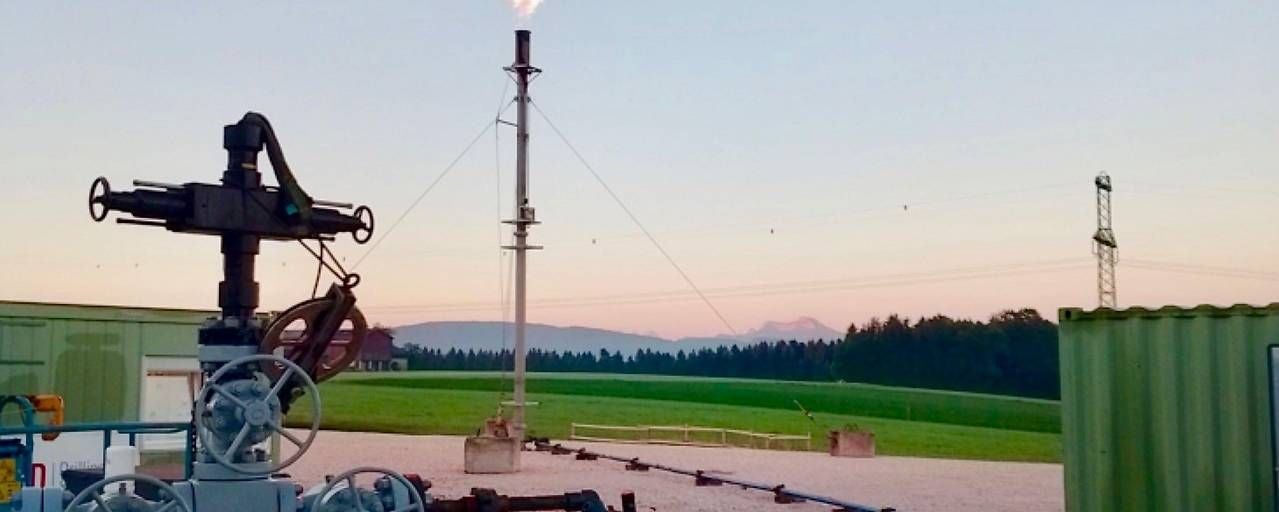 Erdgasbohrstelle mit Förderanlage und brennender Gasfackel auf einem Feld bei Frankenmarkt.