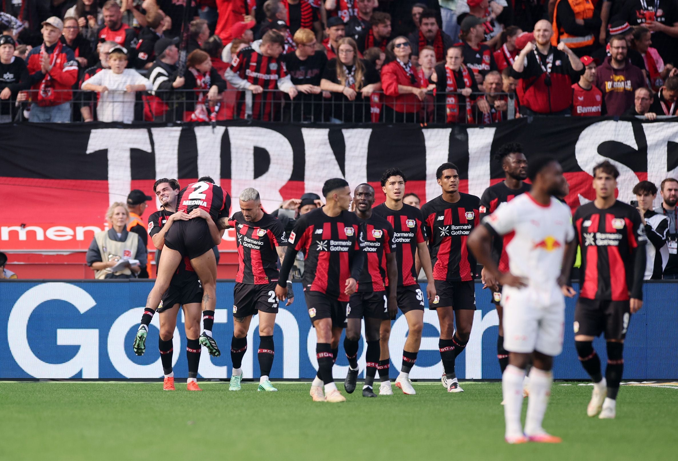 Spieler von Bayer Leverkusen jubeln nach einem Tor vor jubelnden Fans im Stadion.