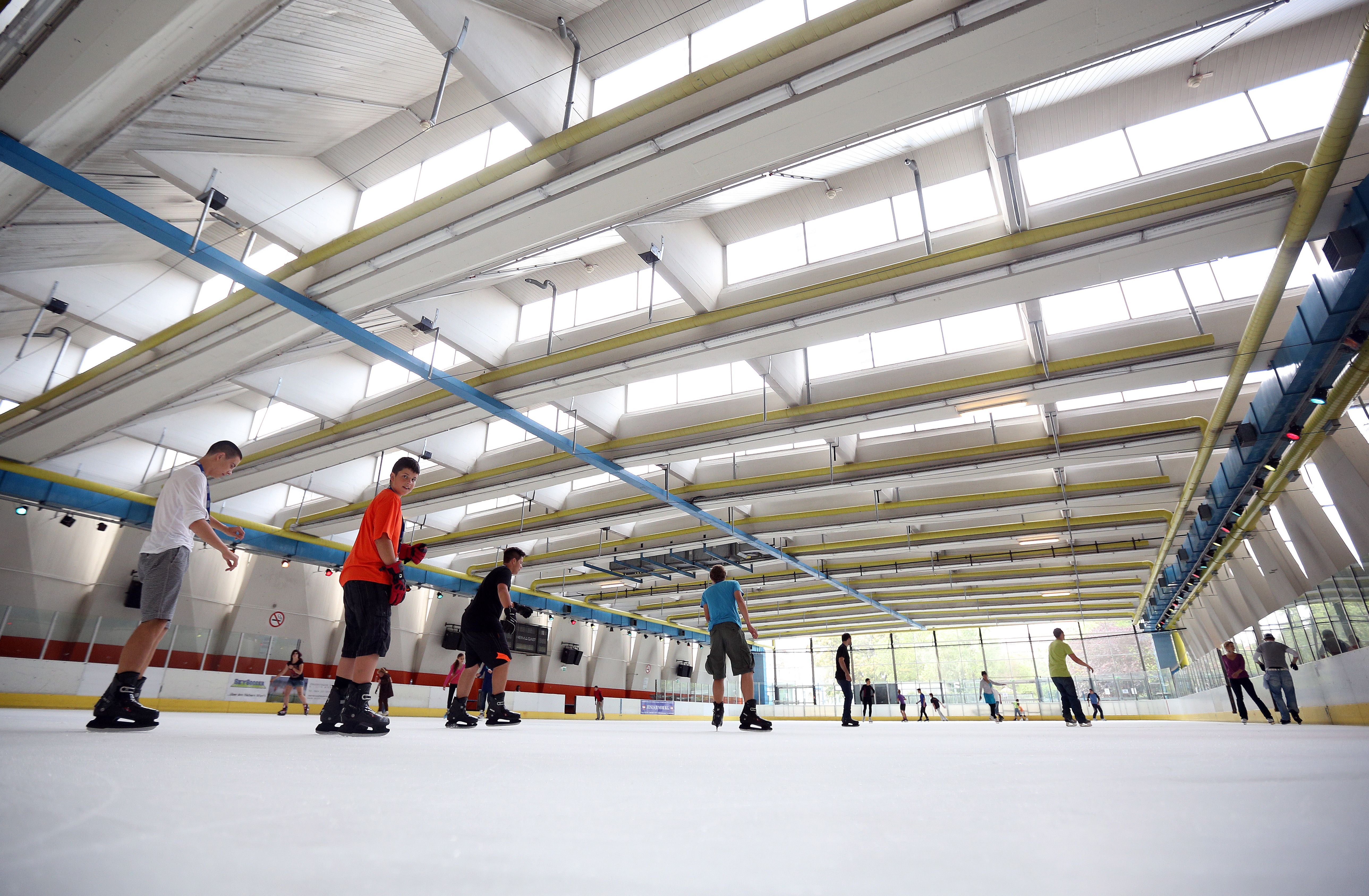 Mehrere Menschen laufen in einer Eishalle auf einer Eisfläche in der Wiener Stadthalle.