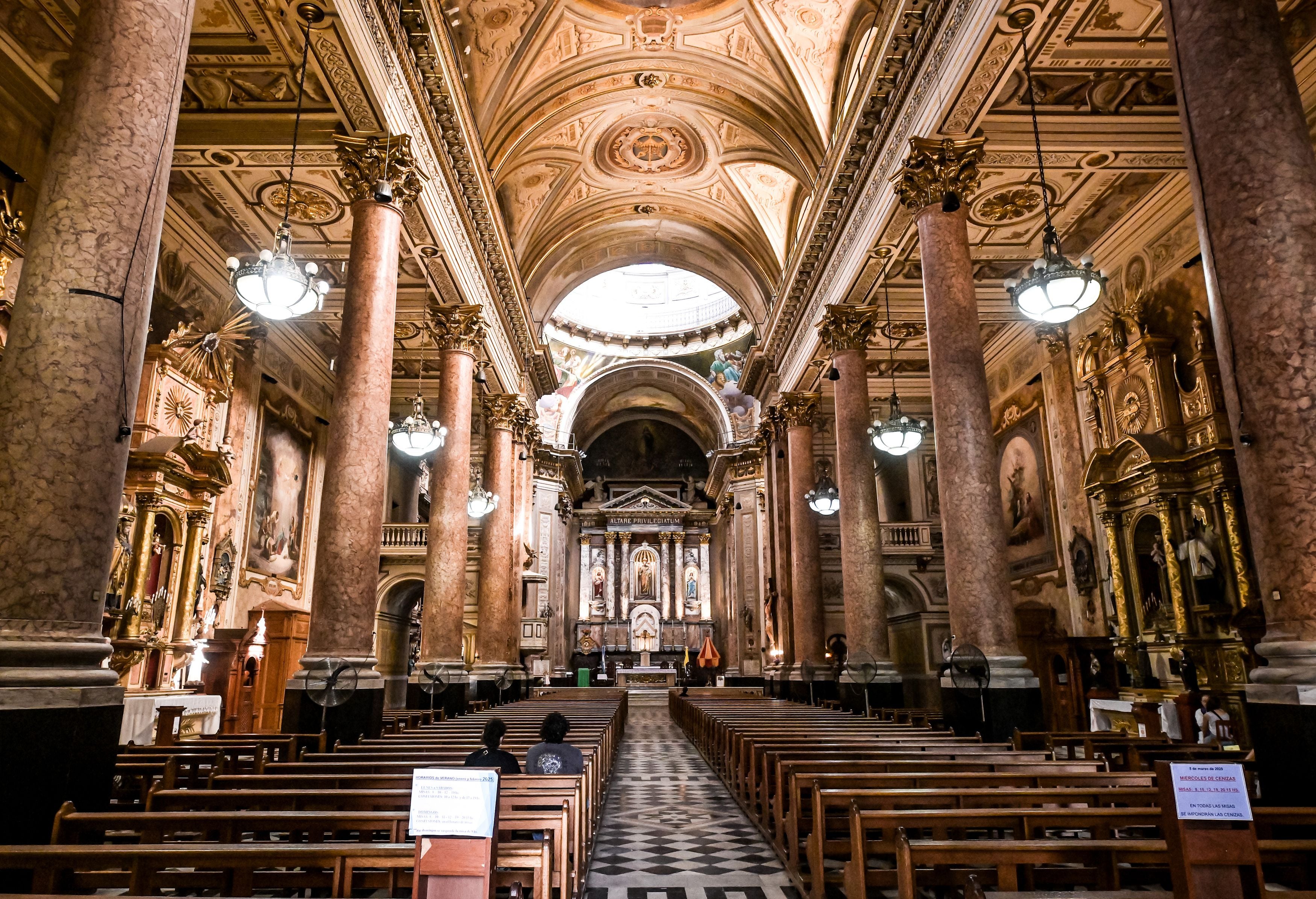 Prunkvolles Kircheninnere mit hohen Säulen, Bänken und verziertem Altar in Buenos Aires.