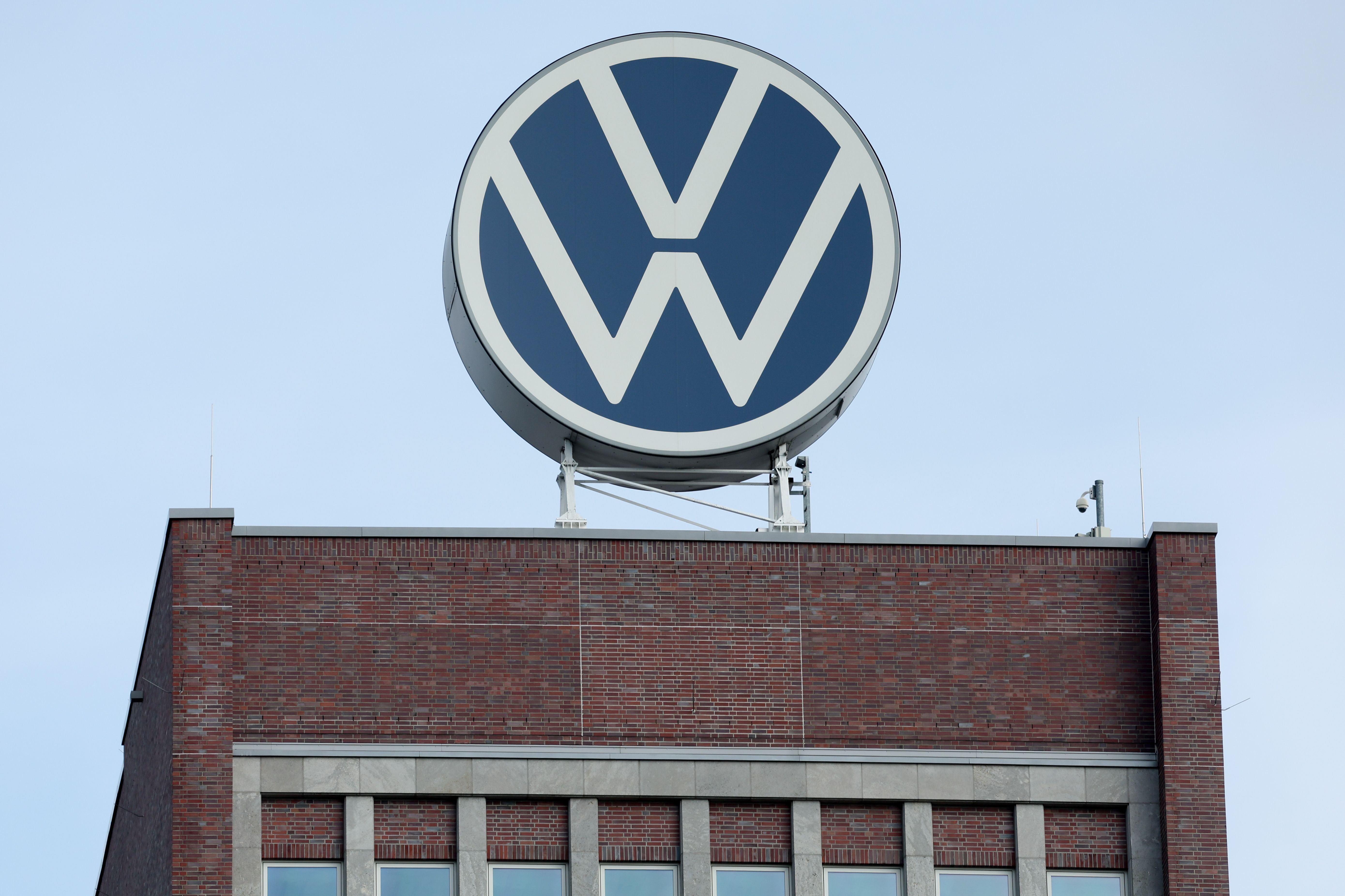 Großes VW-Logo auf dem Dach eines Backsteingebäudes der Volkswagen-Fabrik in Wolfsburg.