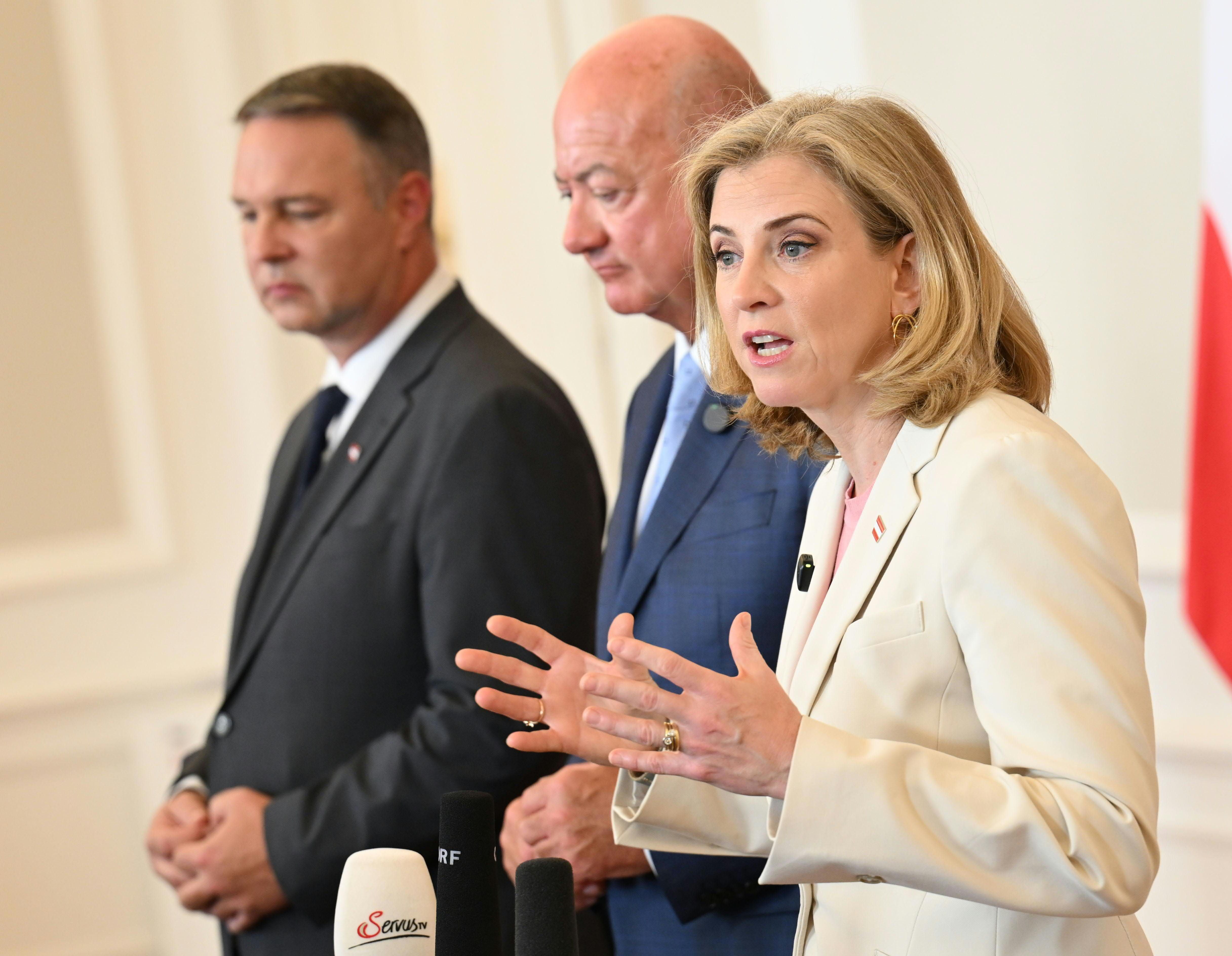 Drei Politiker sprechen bei einer Pressekonferenz im Bundeskanzleramt in Wien vor Mikrofonen.