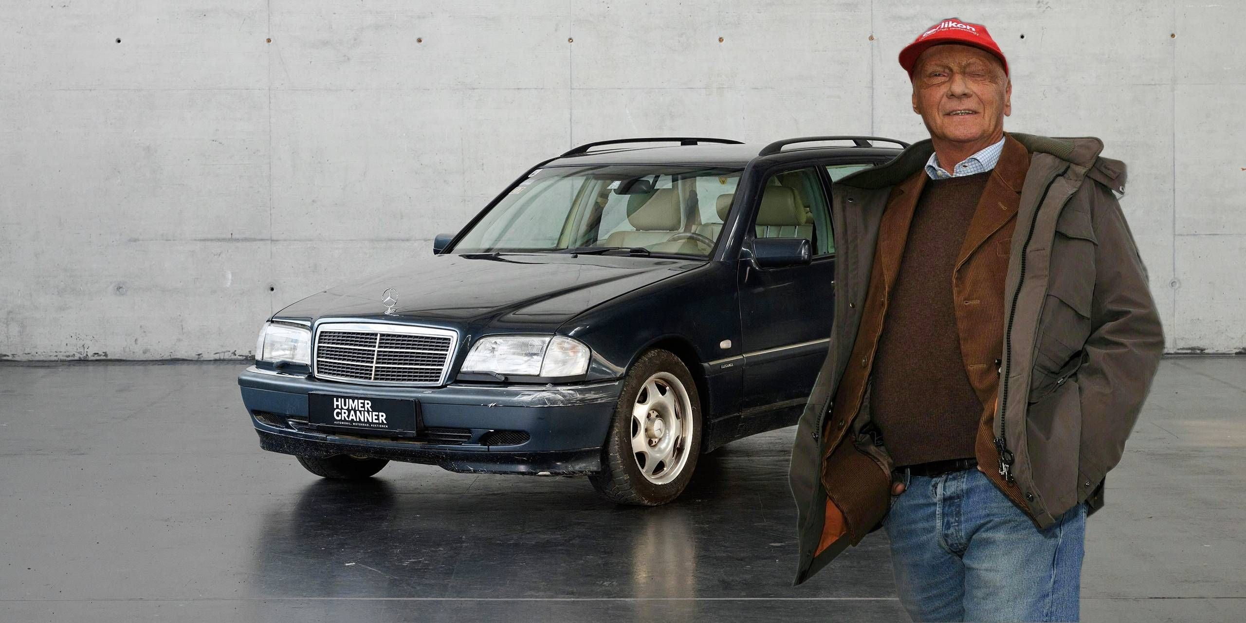 Ein Mann steht vor einem dunkelblauen Mercedes-Benz C230 Kompressor Kombi von 1999.